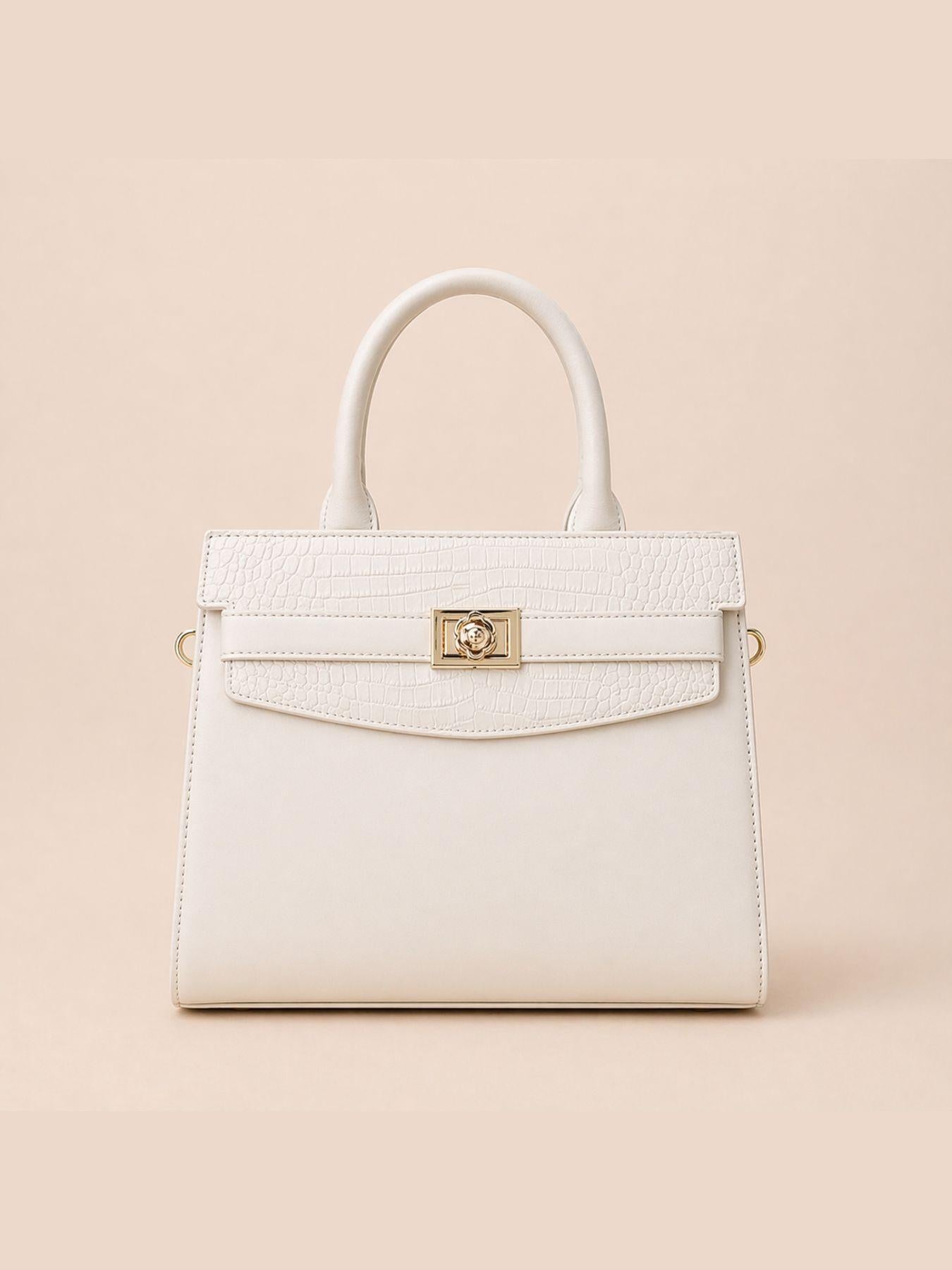 White handbag with gold clasp on a beige background