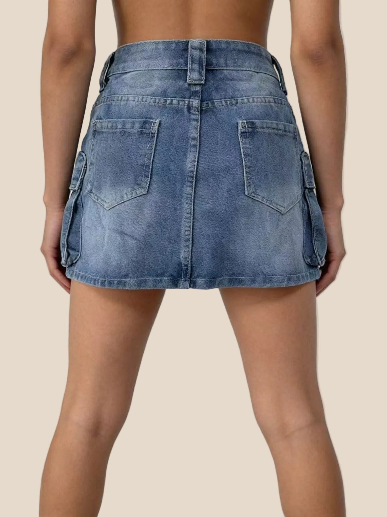 Blue denim skirt worn by a person on a white background