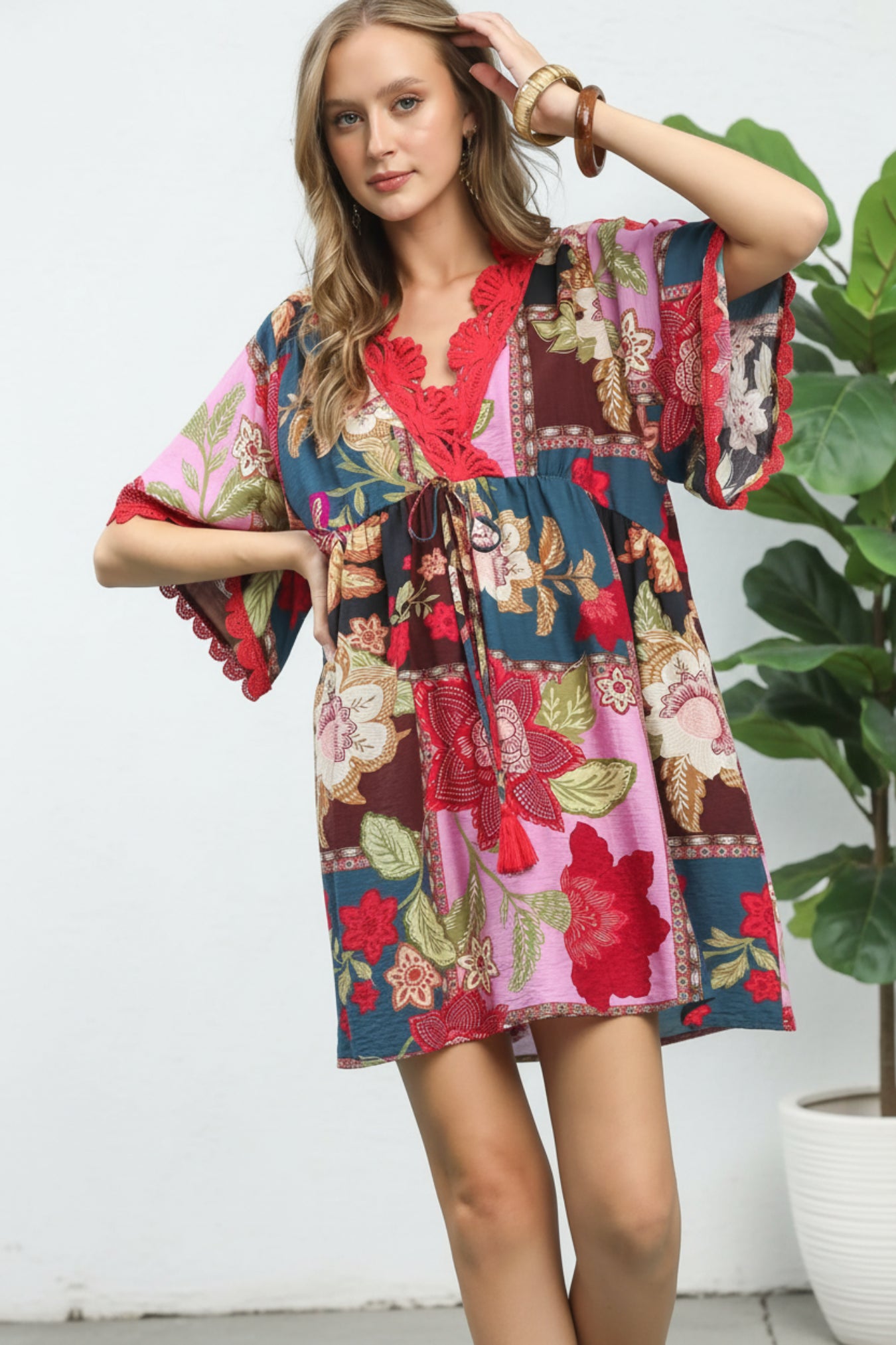 Woman wearing a colorful floral dress against a white background