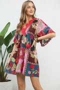 Woman wearing a colorful patchwork dress against a white background