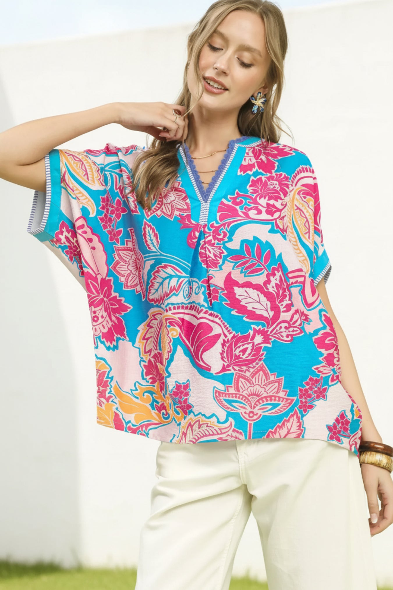 Woman wearing a colorful floral blouse with a white background