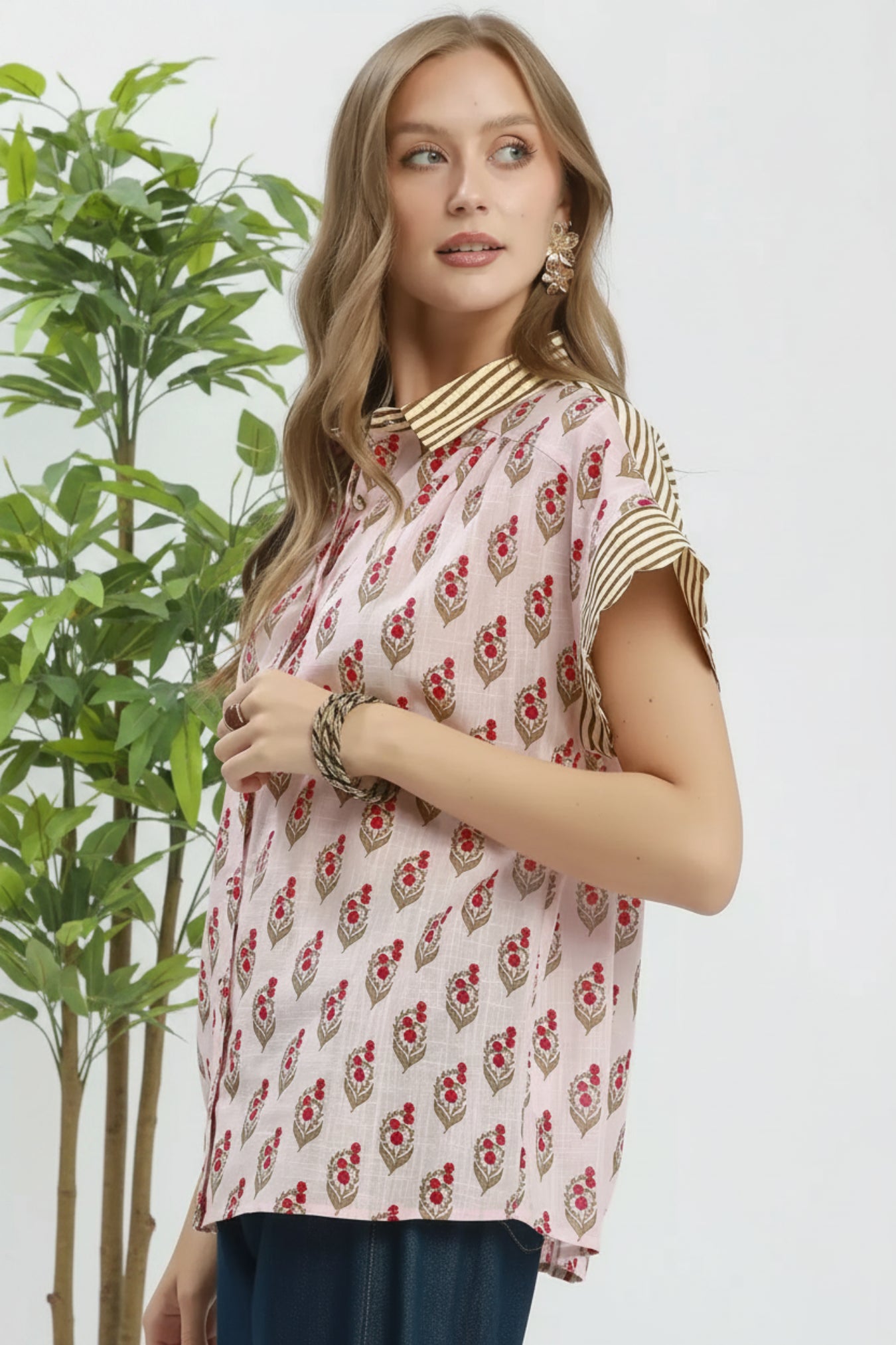 Woman wearing a patterned top with a plain background