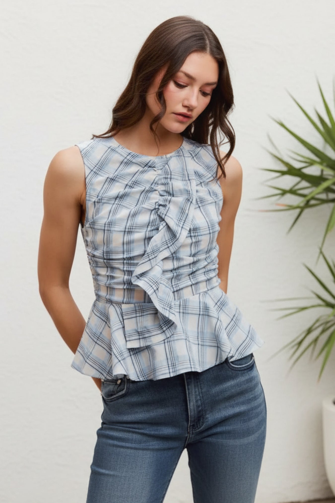 Woman wearing a blue plaid top against a white background