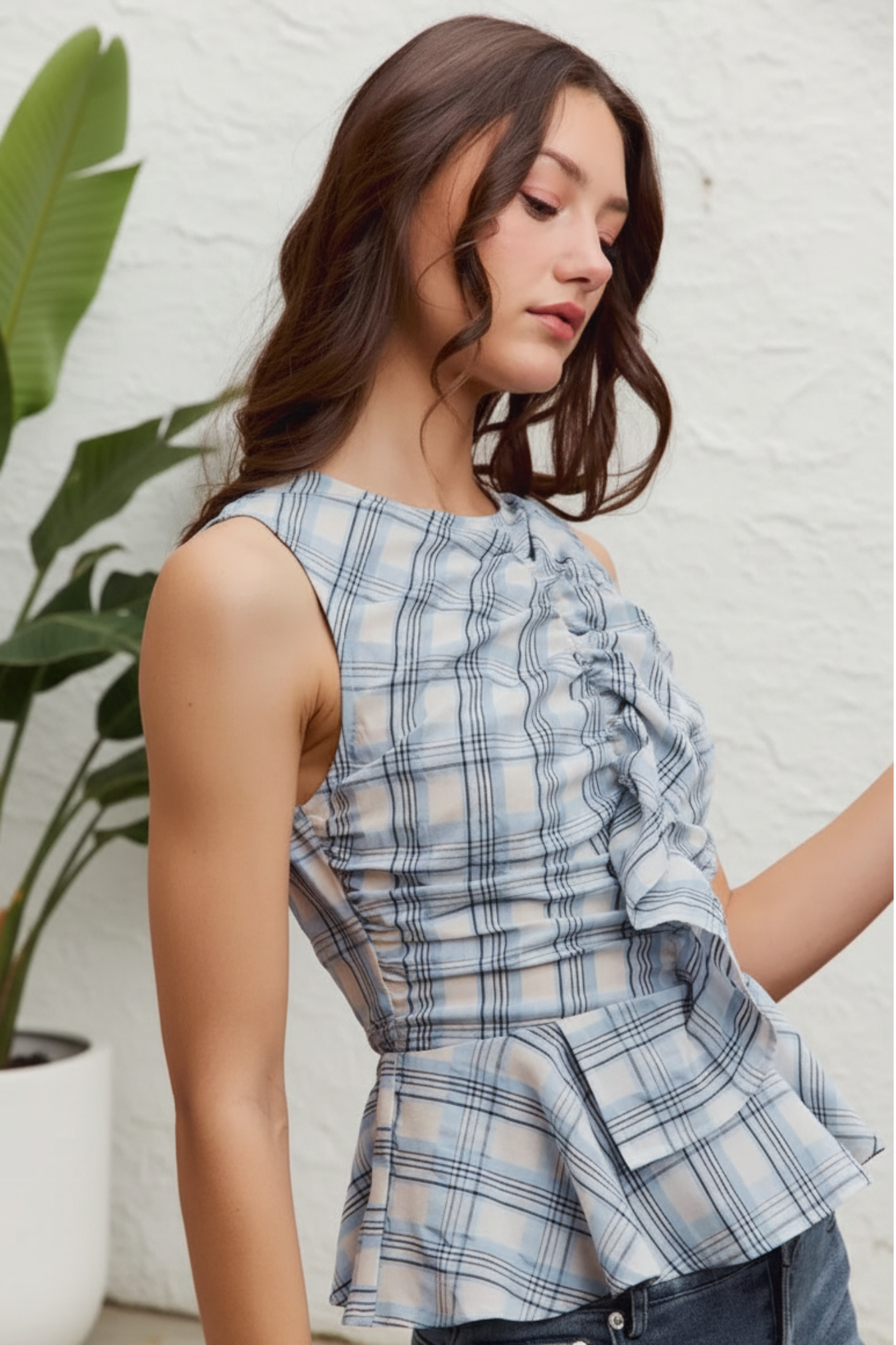 Woman wearing a plaid top against a white background