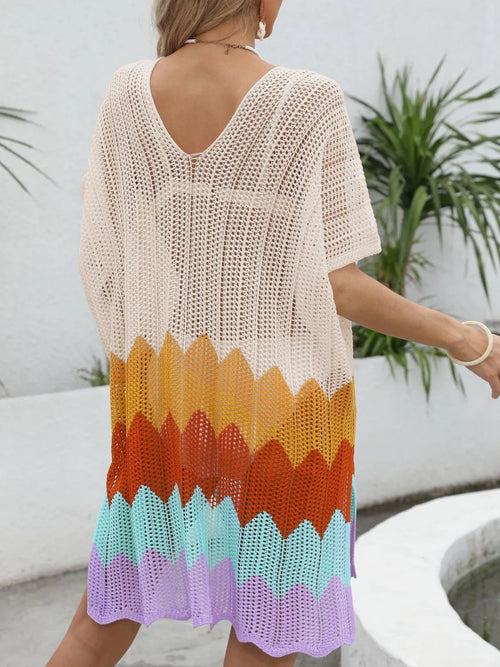 Woman wearing a colorful crochet cover-up with a plant and white wall in the background