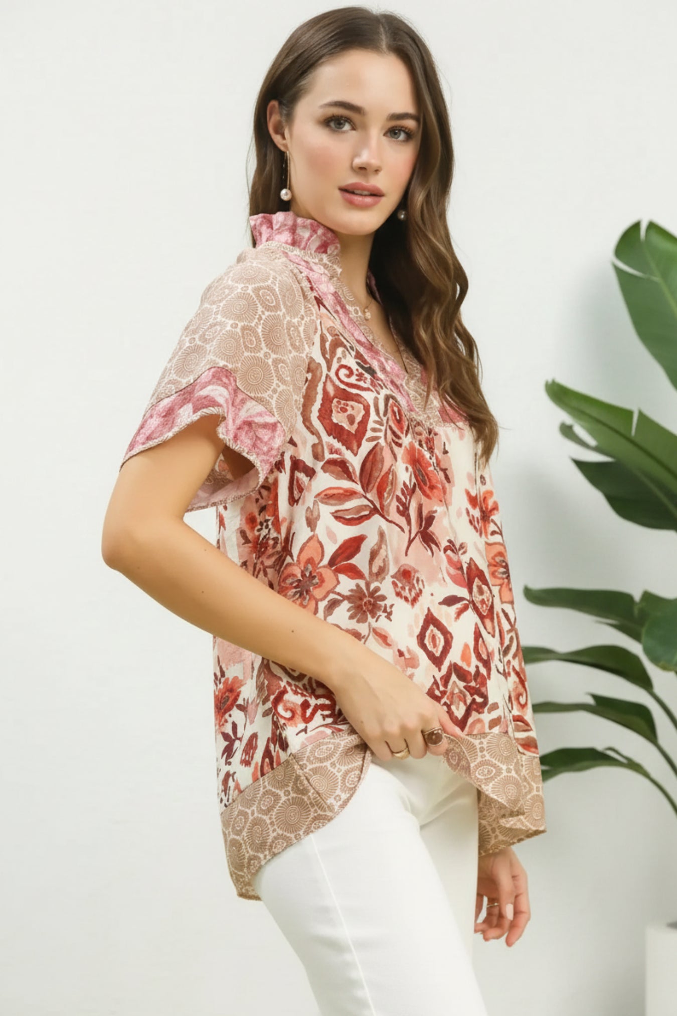 Woman wearing a floral patterned blouse against a light white background
