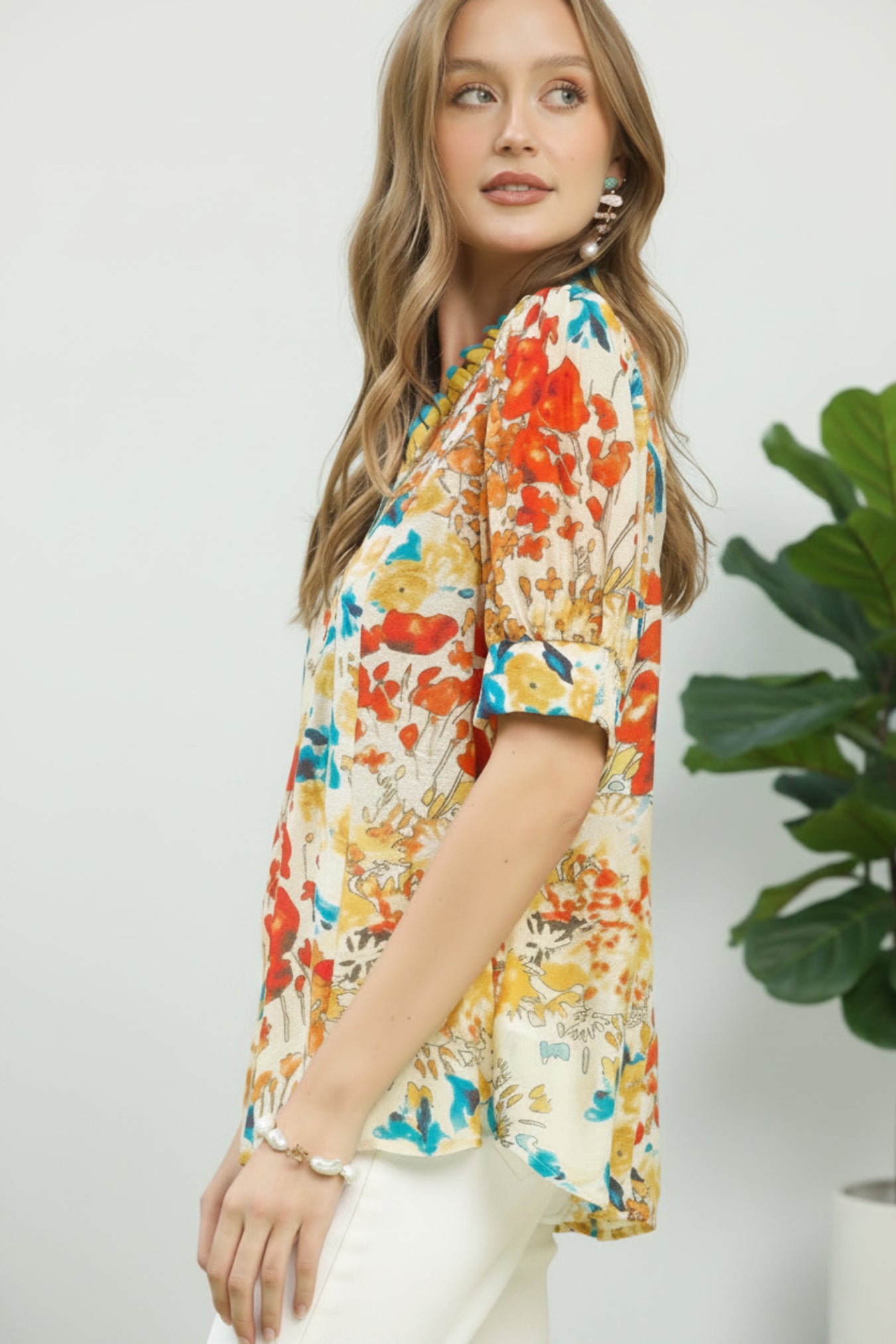 Woman wearing a colorful floral blouse against a white background