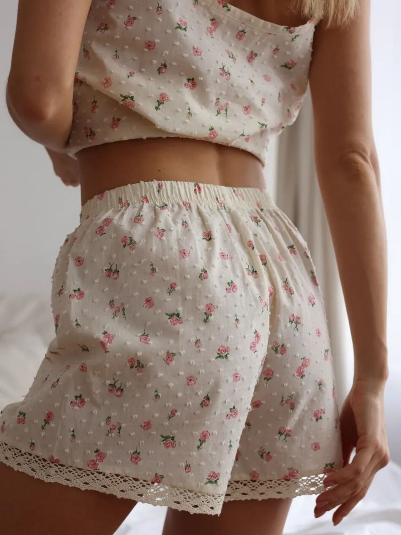 Person wearing a floral top and shorts set on a neutral background
