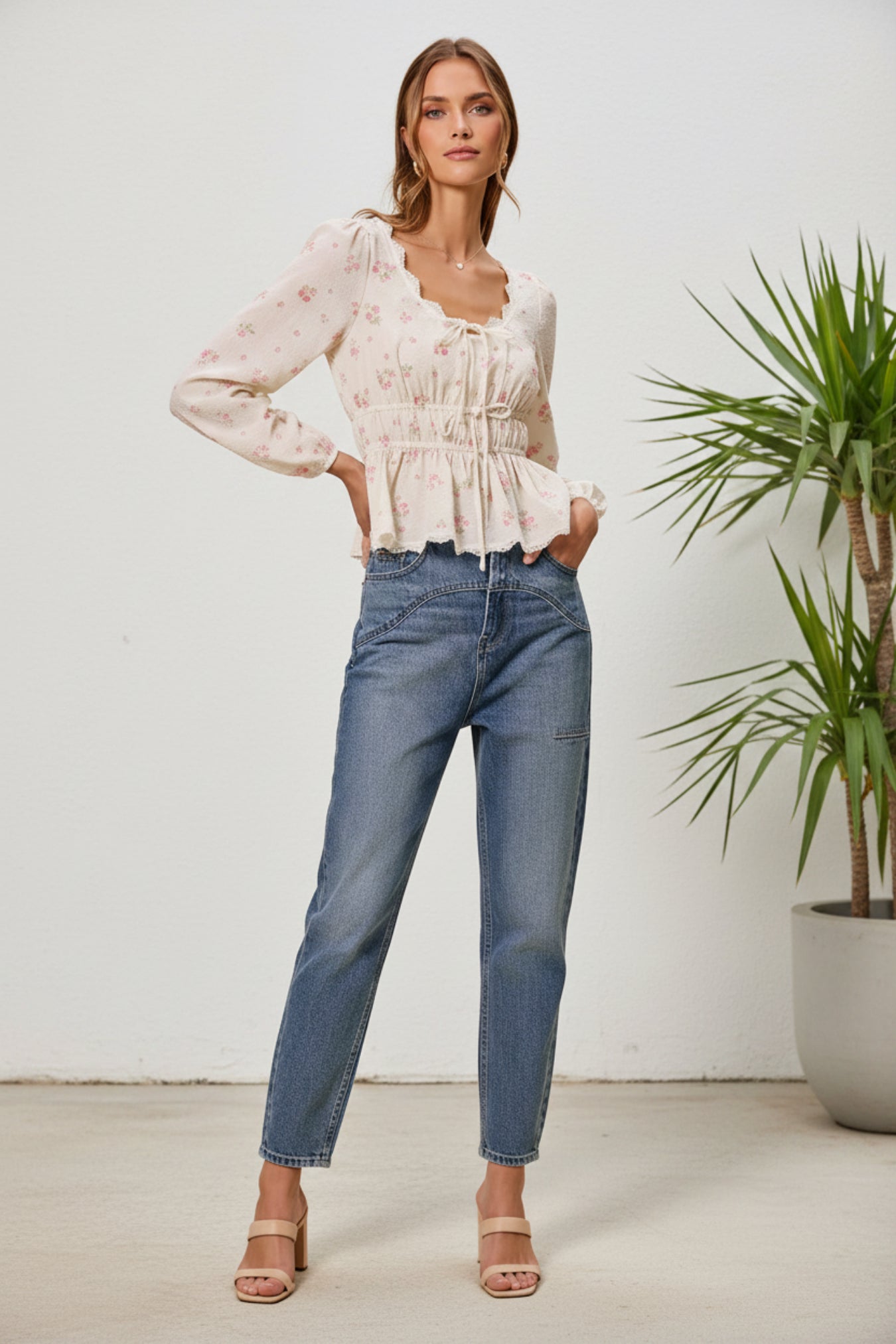 Woman wearing a white blouse and blue jeans on a beige background