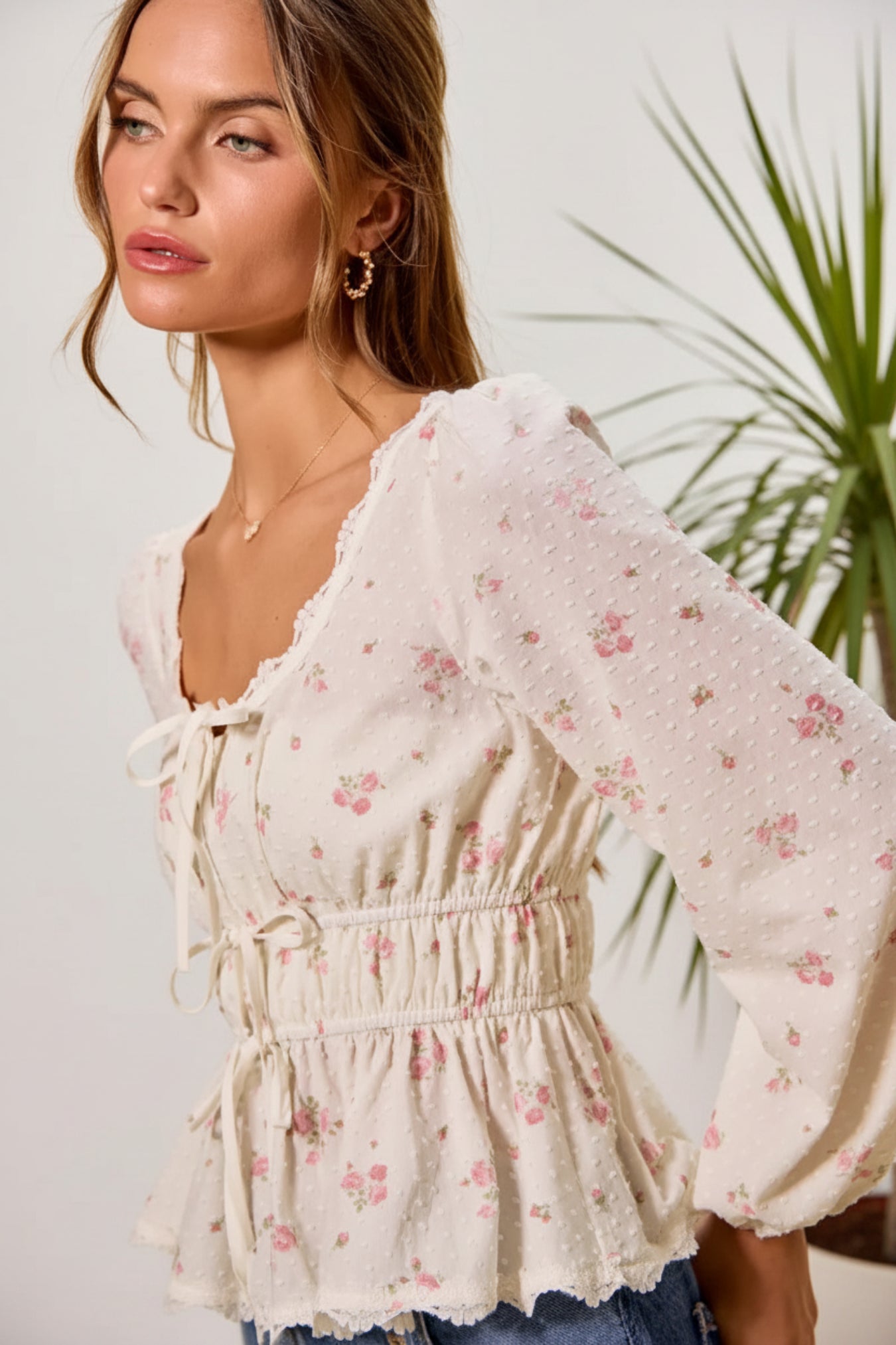 Woman wearing a floral blouse against a beige background