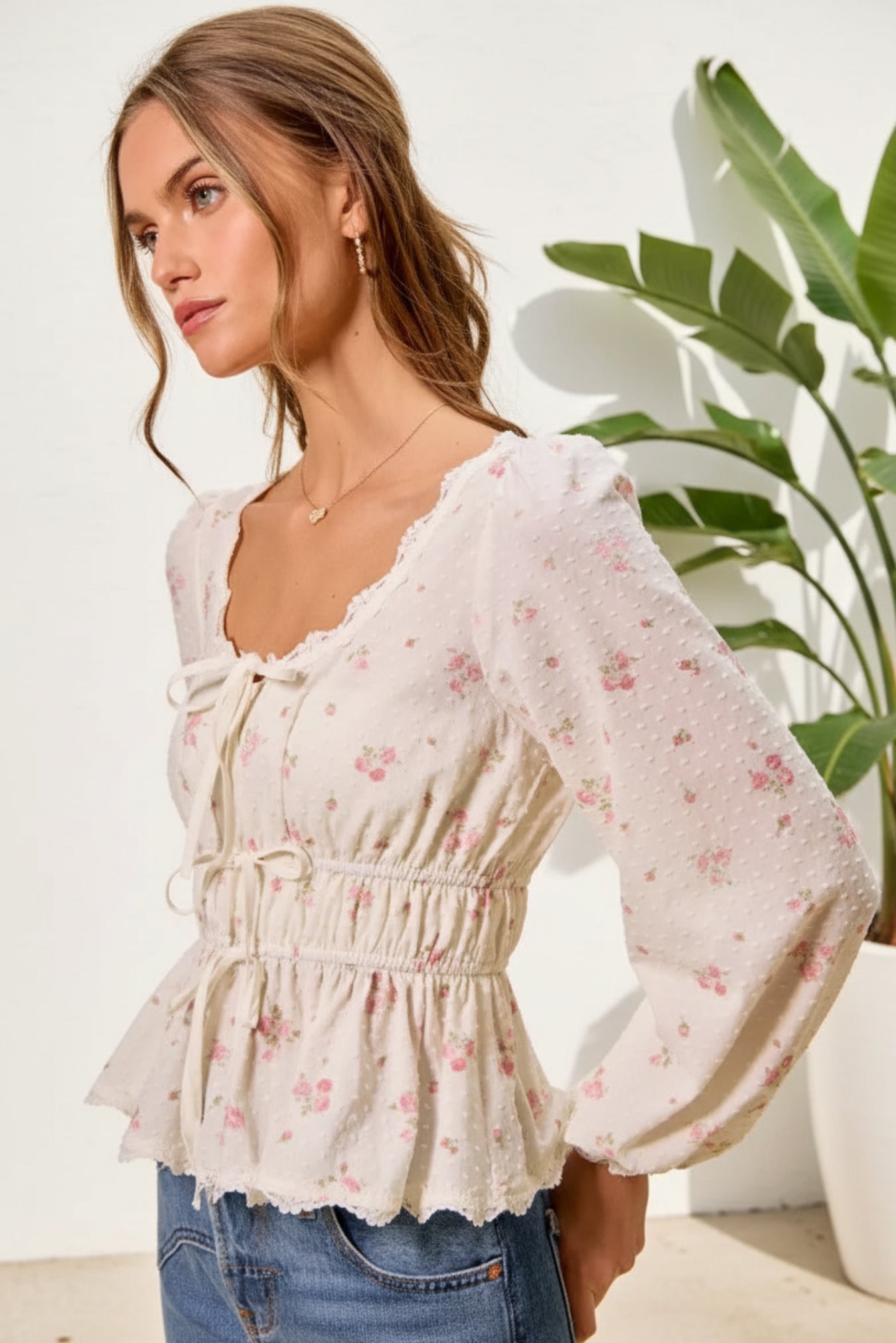 Woman wearing a floral blouse with long sleeves on a beige background