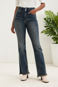Person wearing blue jeans and white shoes on a plain background