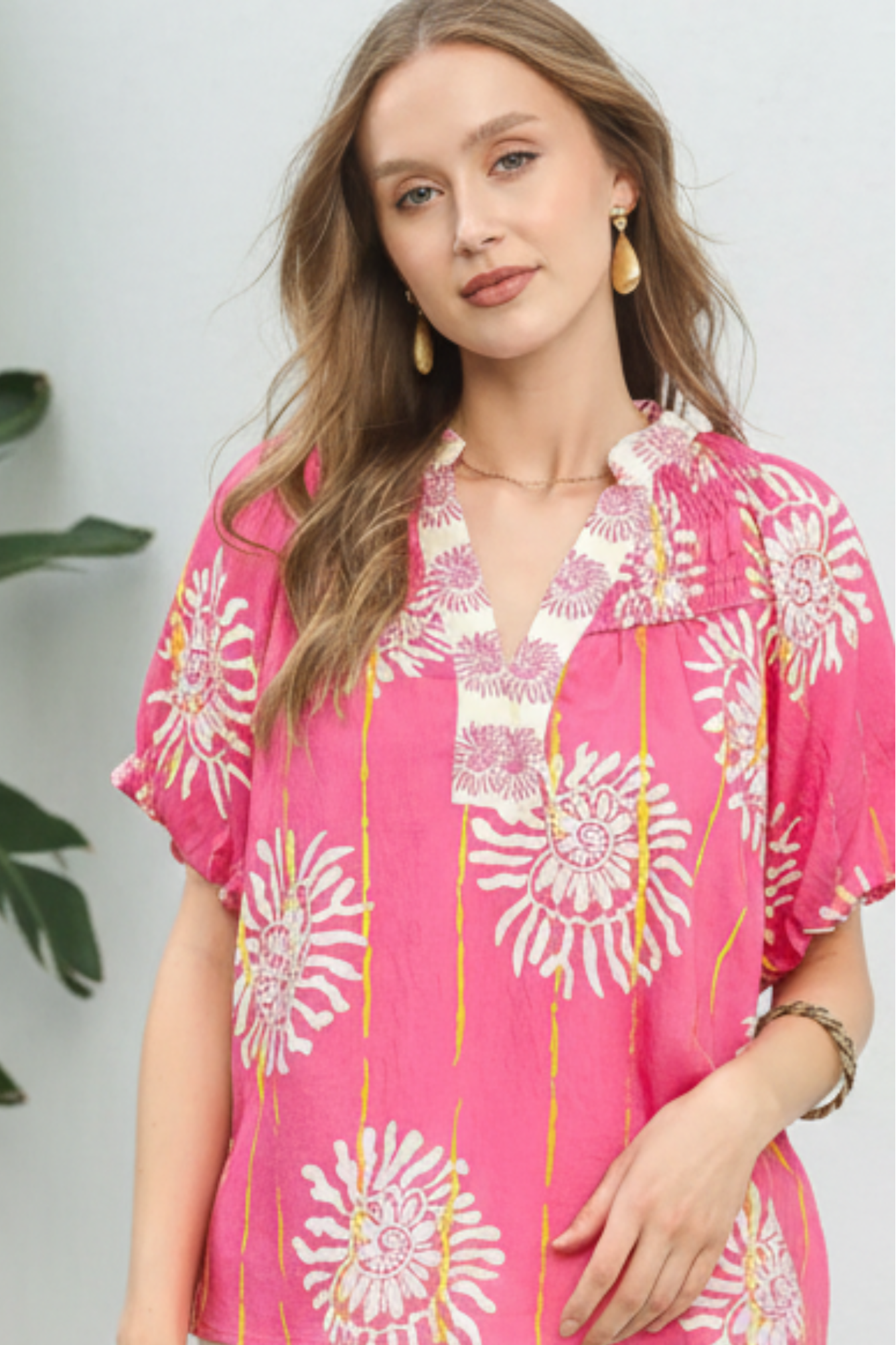 Woman wearing a pink floral blouse with a white background