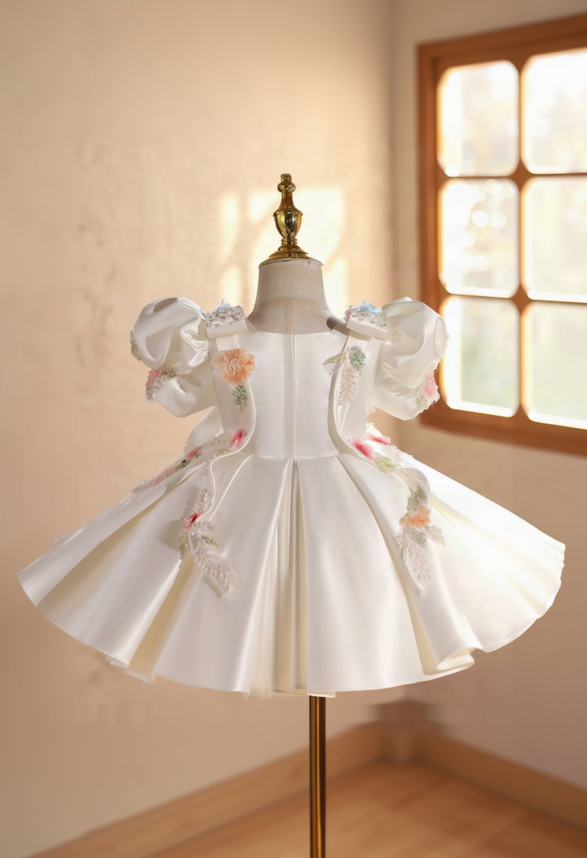 White dress with floral embroidery on a mannequin against a neutral background