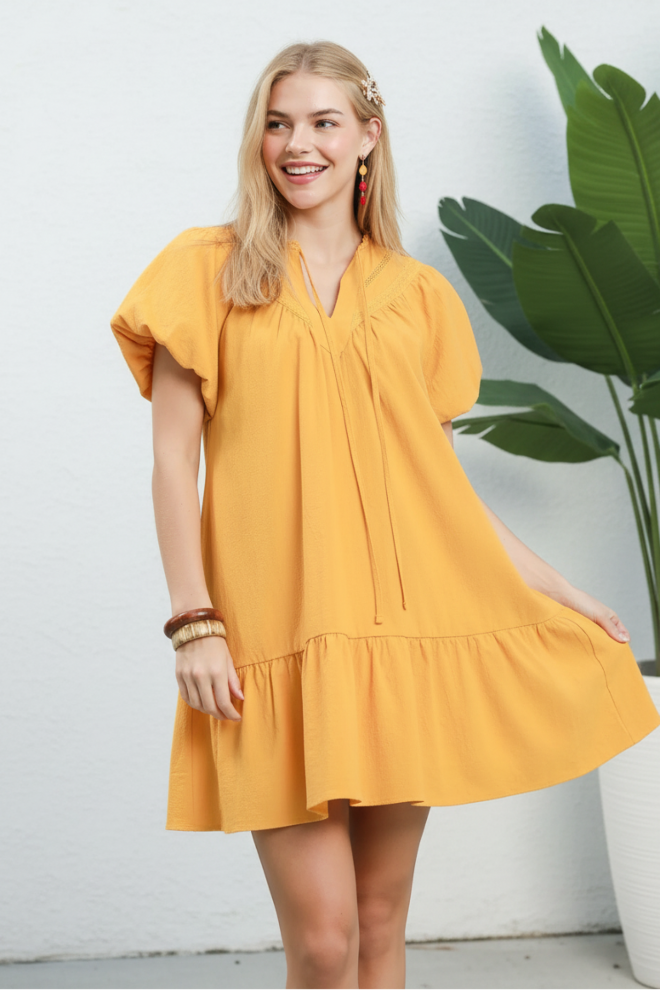 Woman wearing a yellow dress against a light blue background