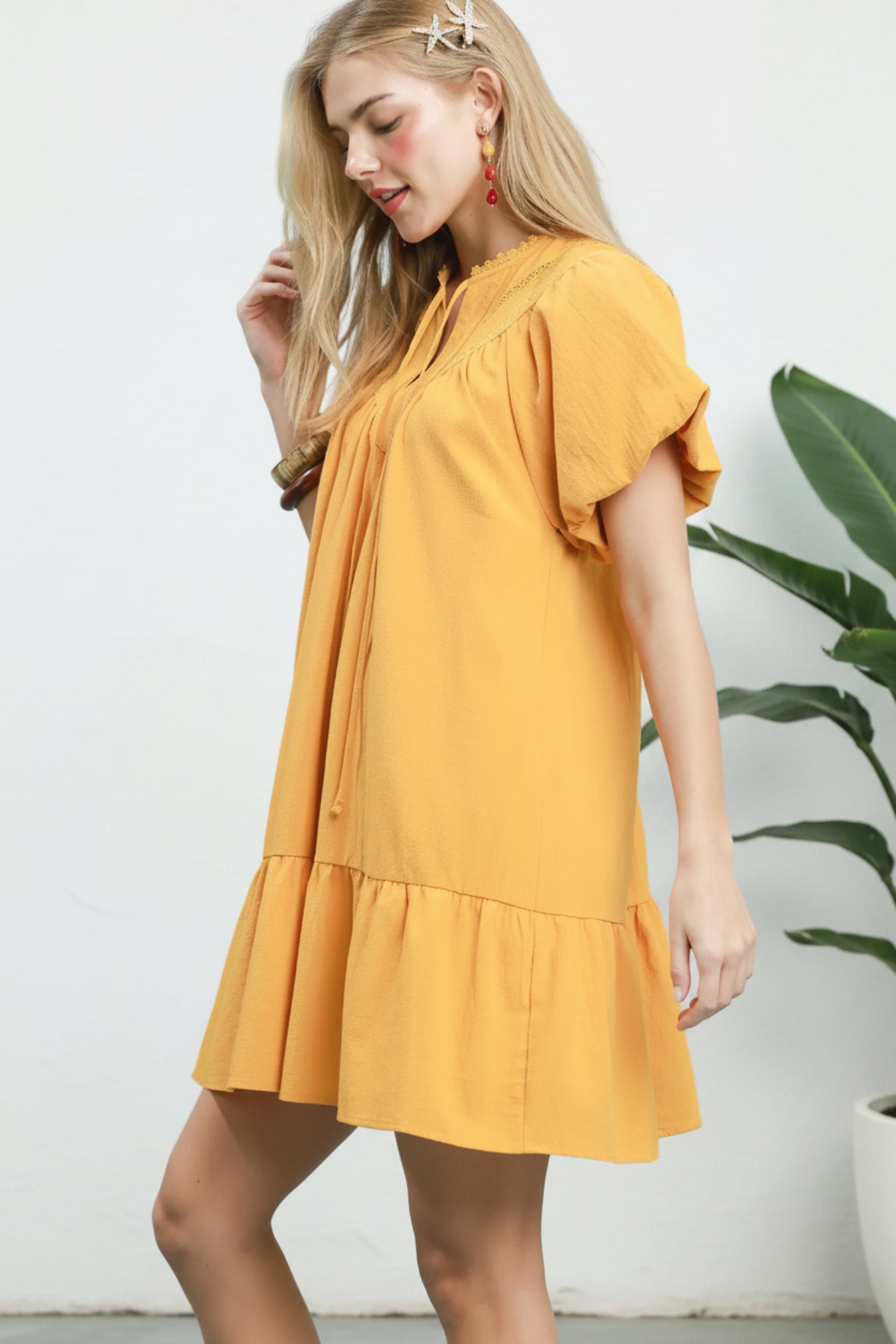 Woman wearing a yellow dress against a light blue background