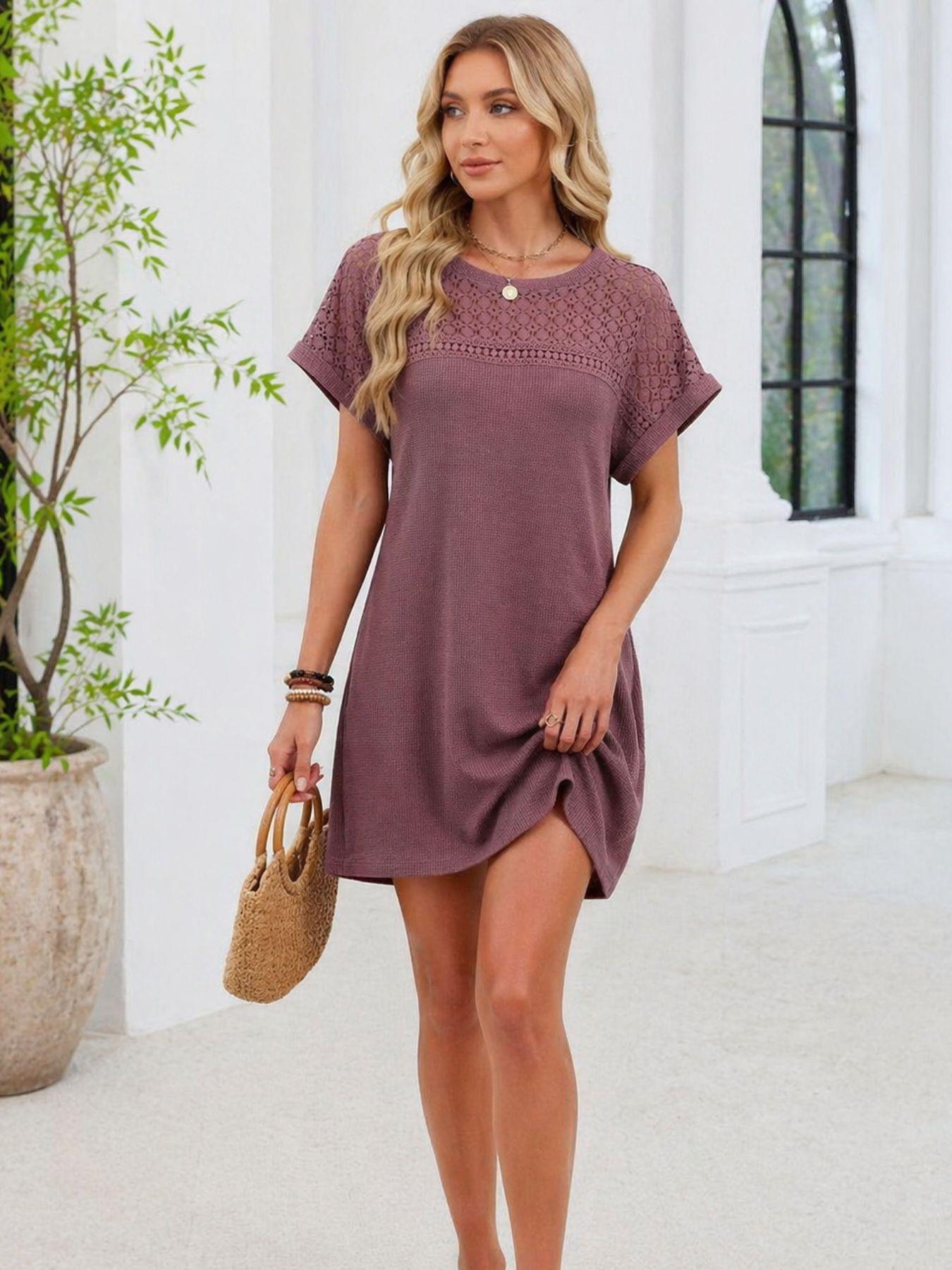 Woman wearing a purple dress holding a straw bag indoors.