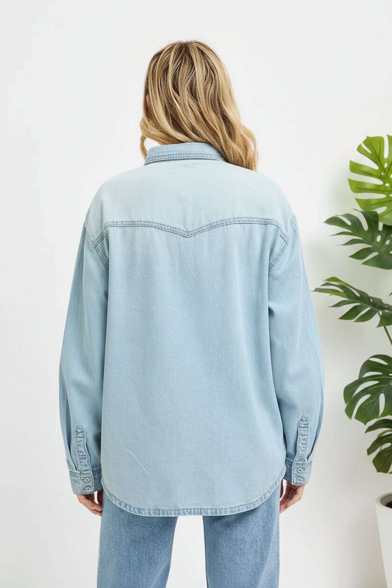Light blue denim jacket worn by a person on a white background
