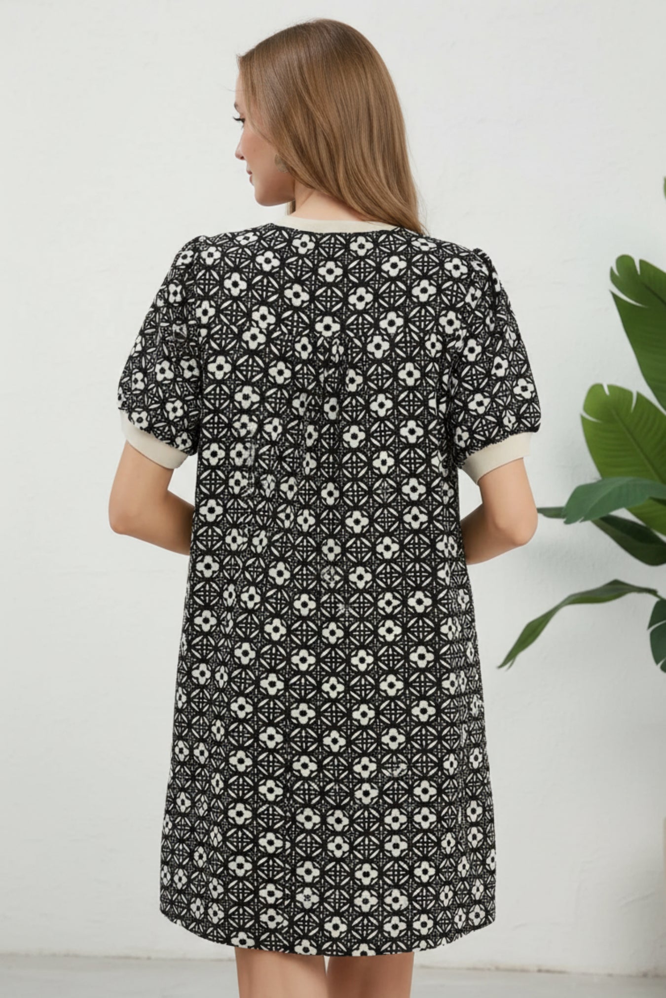 Woman wearing a black patterned dress on a white background