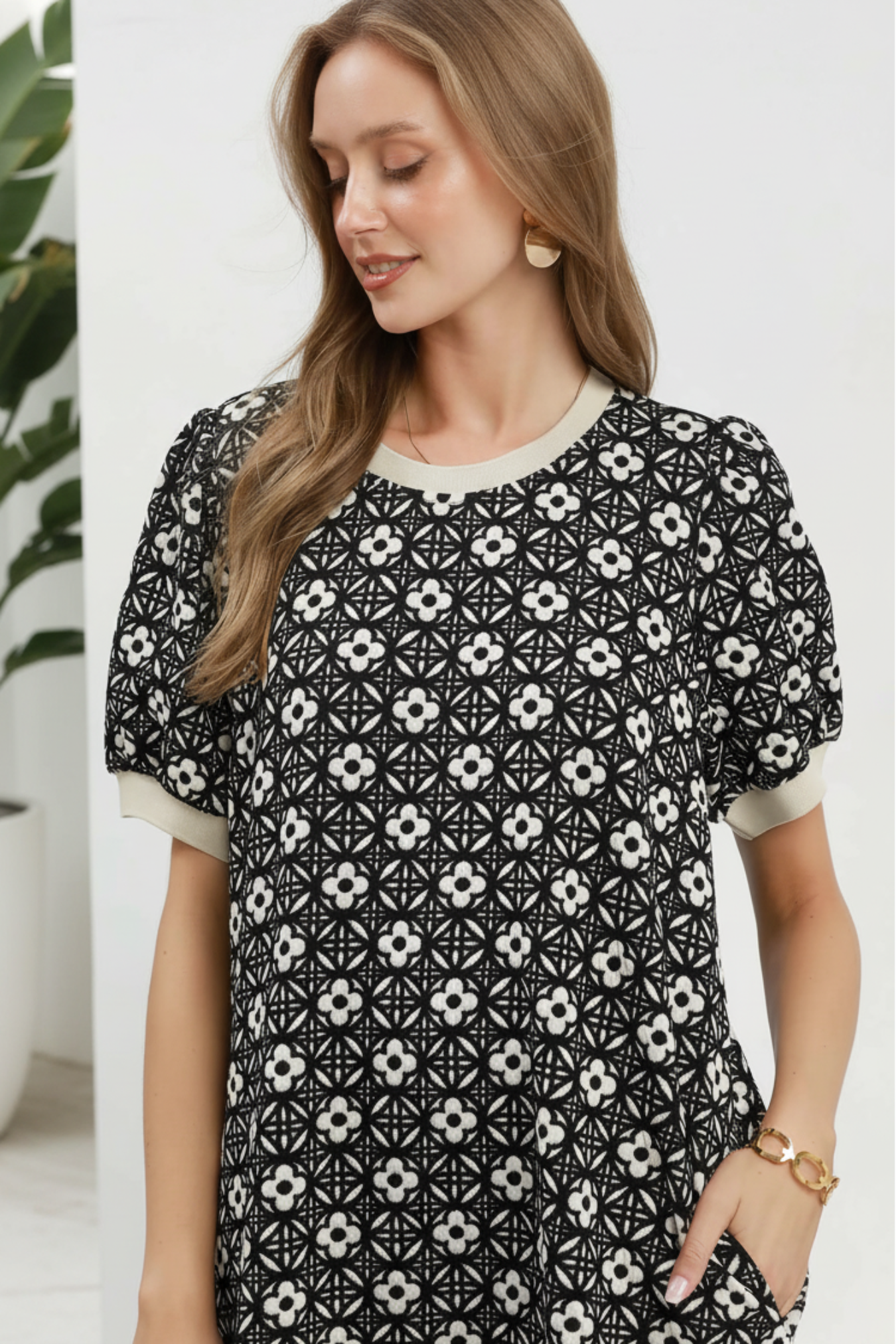 Woman wearing a black and white patterned dress on a plain background