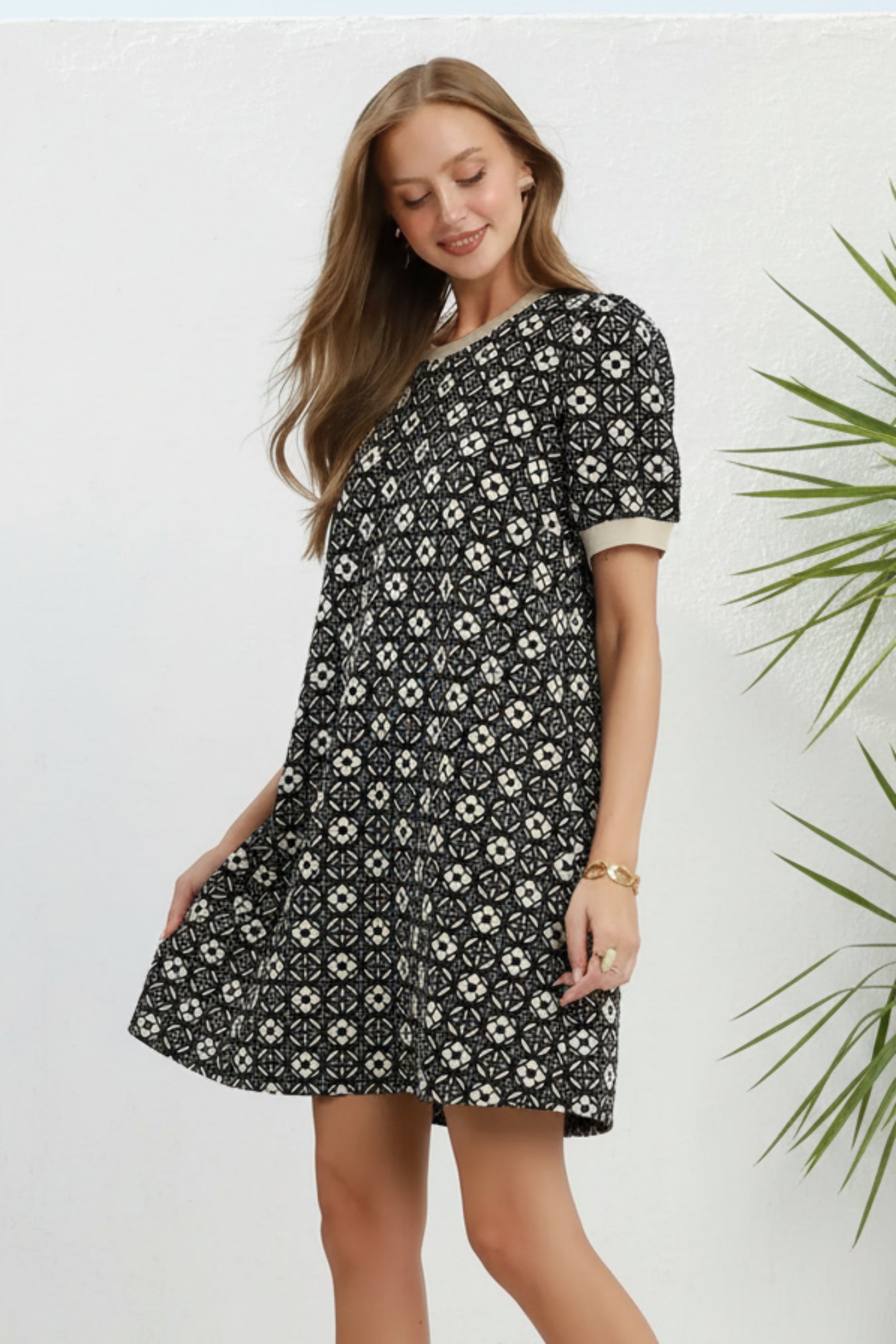Woman wearing a black patterned dress on a white background