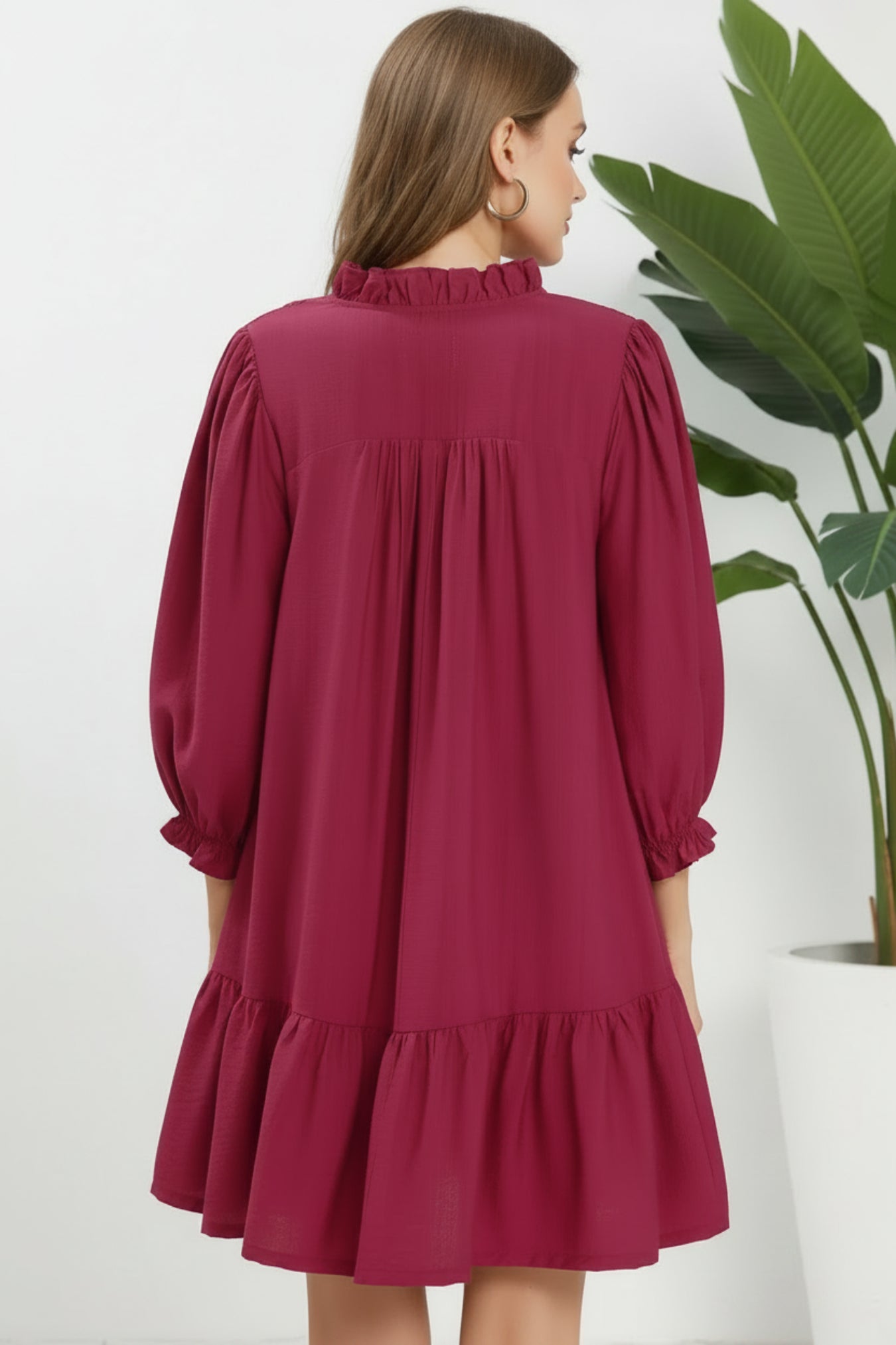Woman wearing a mulberry dress on a white background