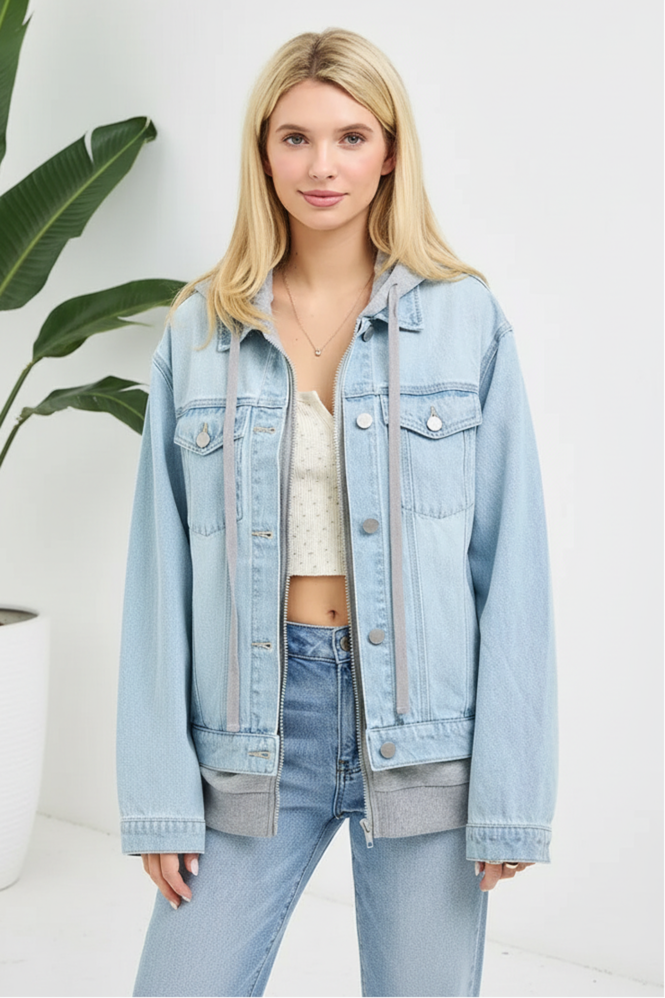 Woman wearing a light blue denim jacket and jeans on a white background