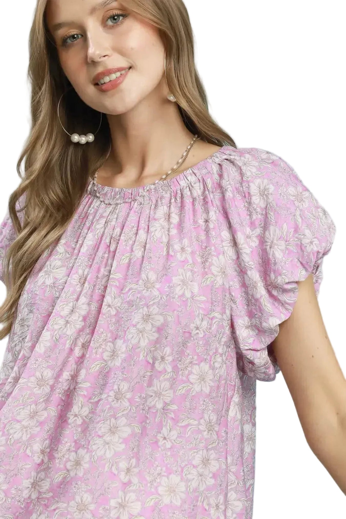 Woman wearing a pink floral blouse against a white background