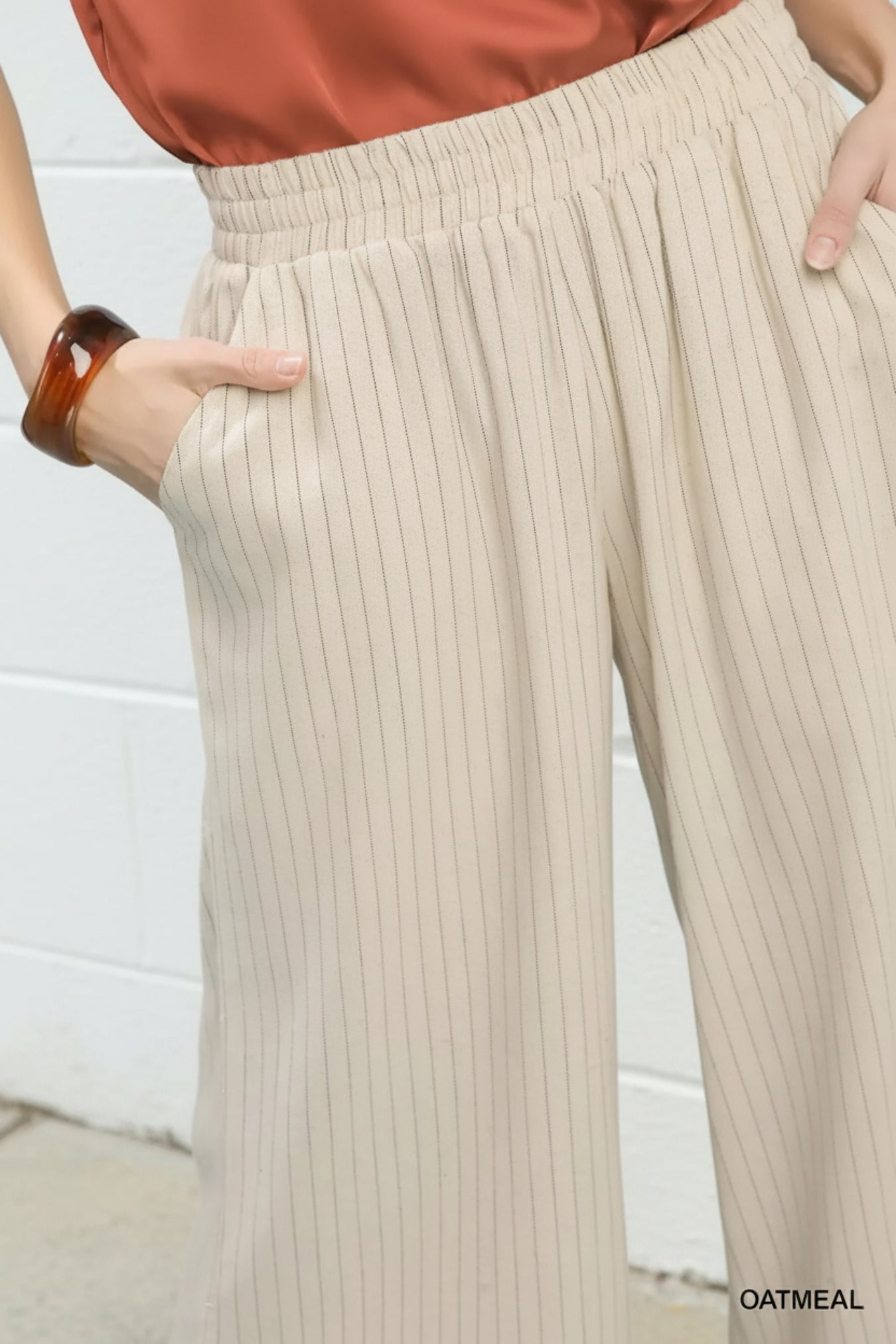 Beige ribbed pants worn by a person against a white background