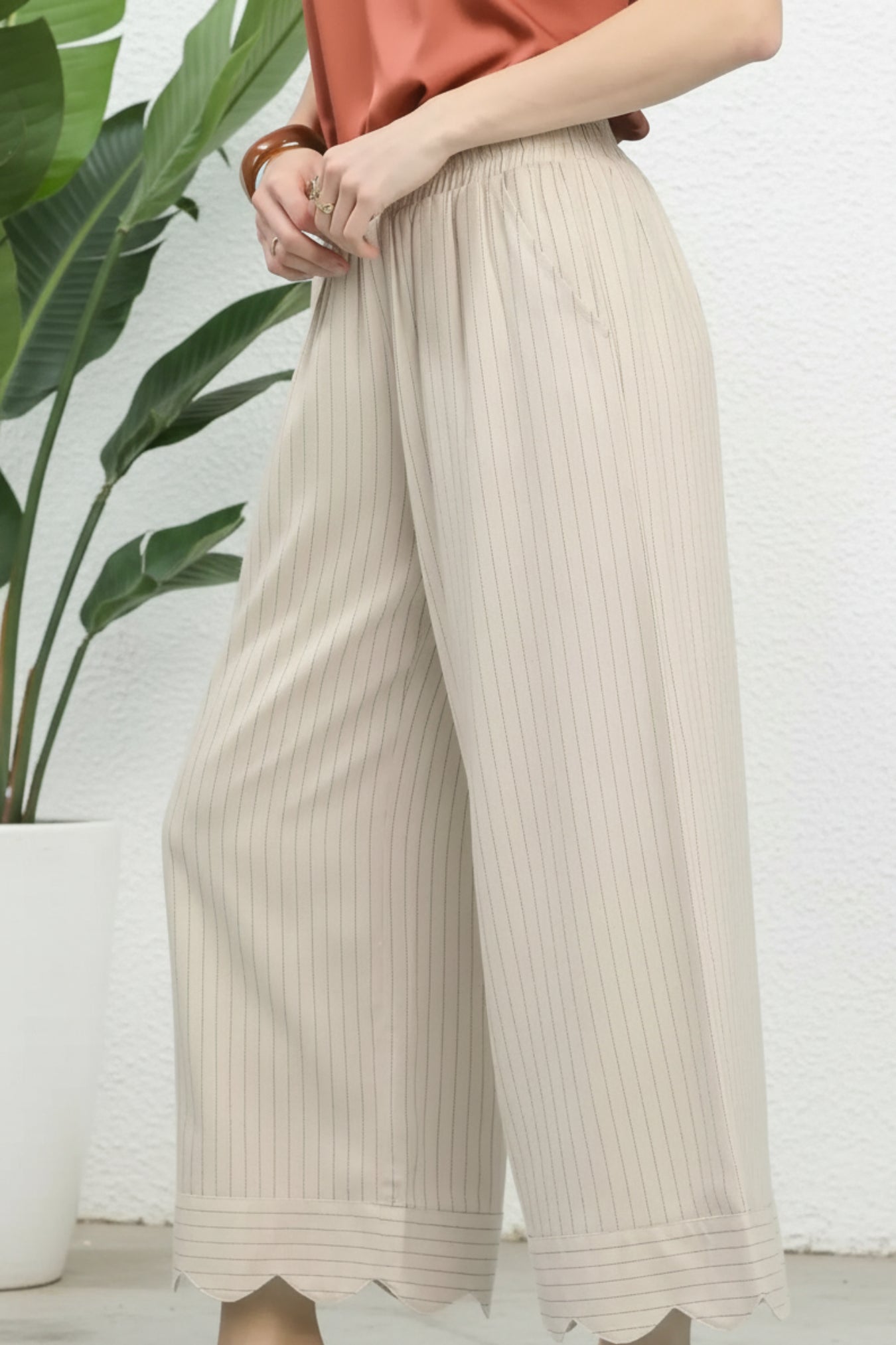 Beige ribbed wide-leg pants worn by a person on a white background
