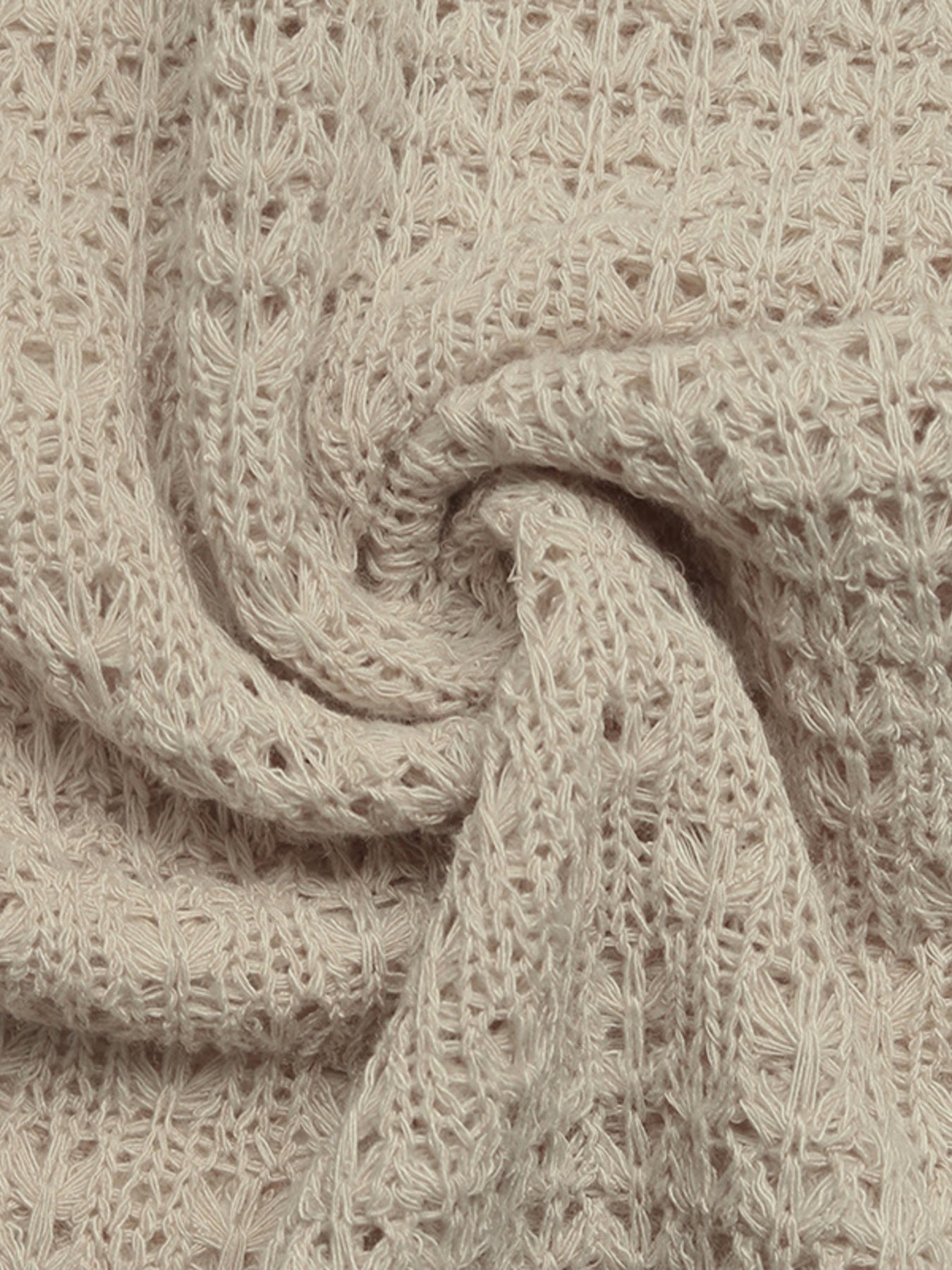 Close-up of beige knitted fabric with a textured pattern