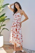 Woman in a floral dress standing outdoors near a plant