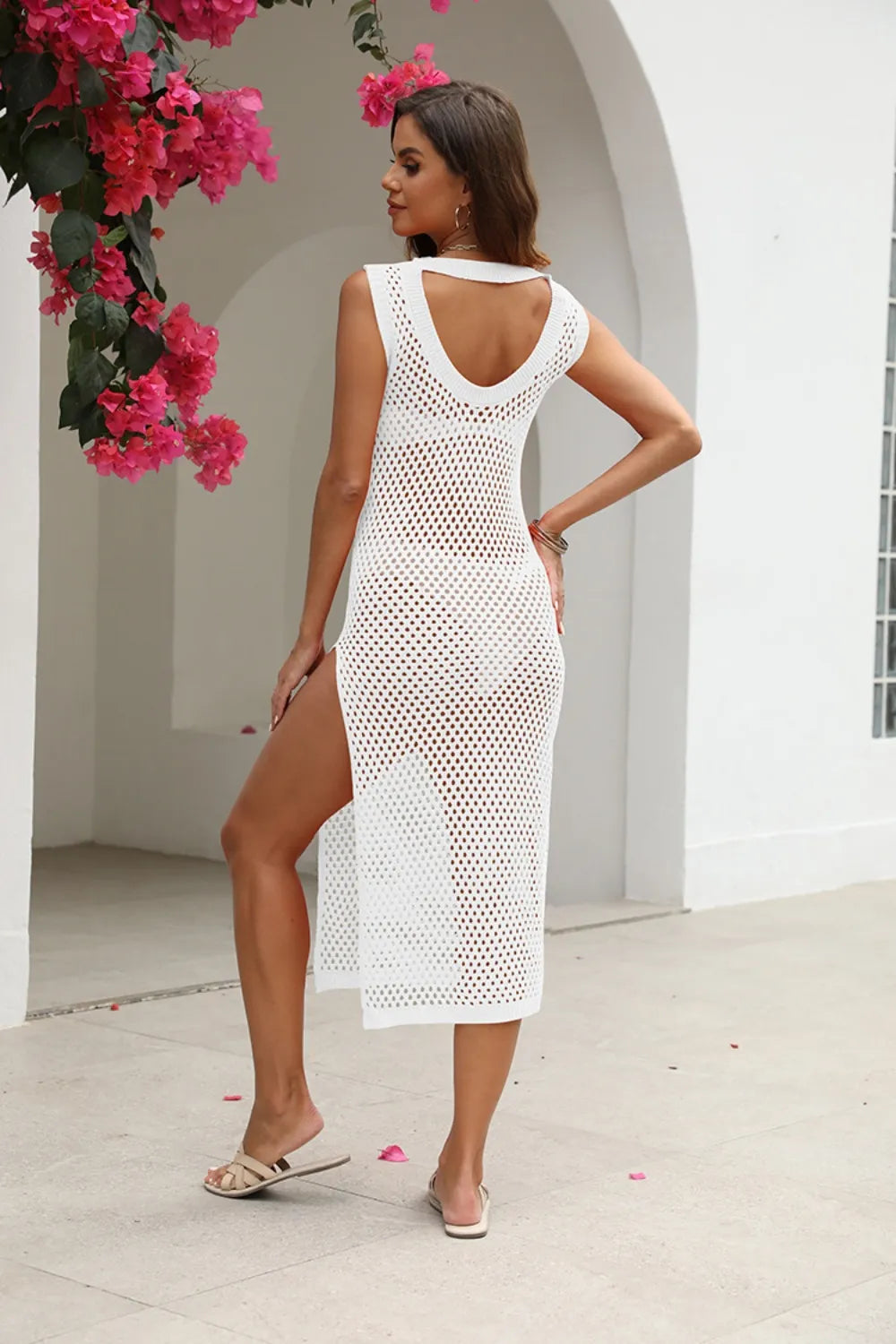 Woman wearing a white crochet dress with a floral background