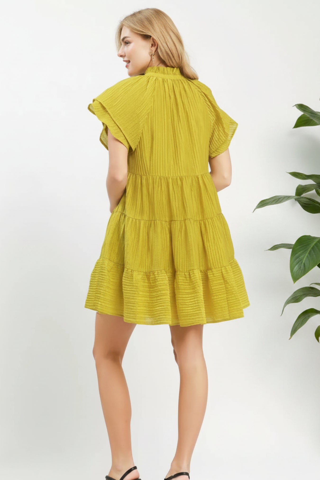 Woman wearing a yellow dress on a white background