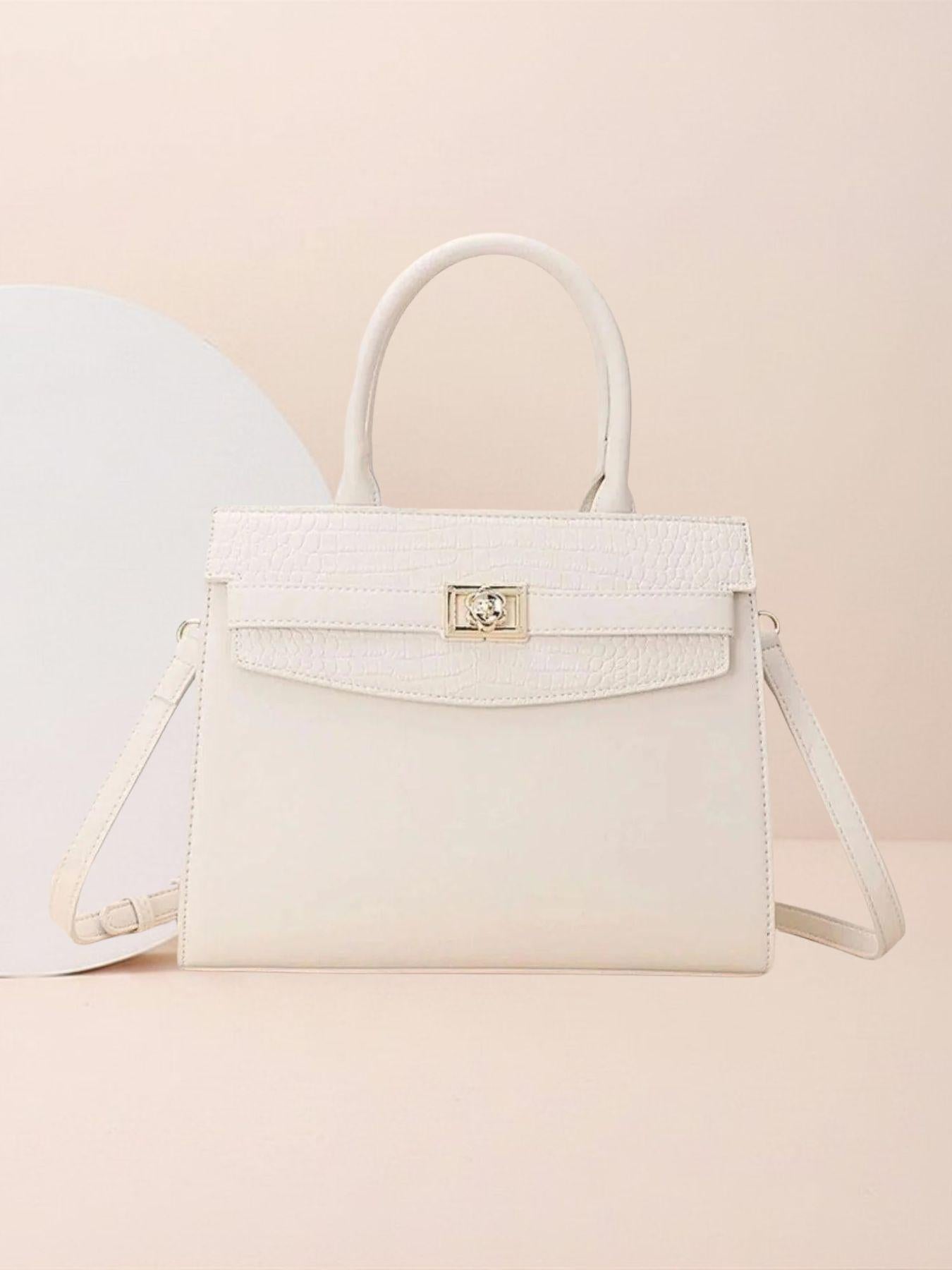 White handbag with gold clasp on a beige background