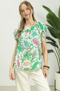 Woman wearing a colorful patterned top with a white background