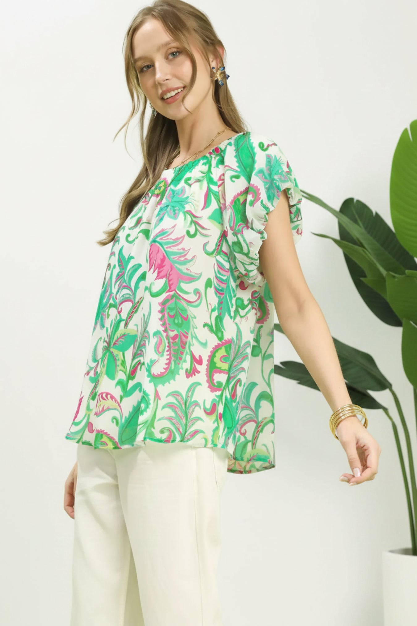 Woman wearing a colorful floral blouse with a white background