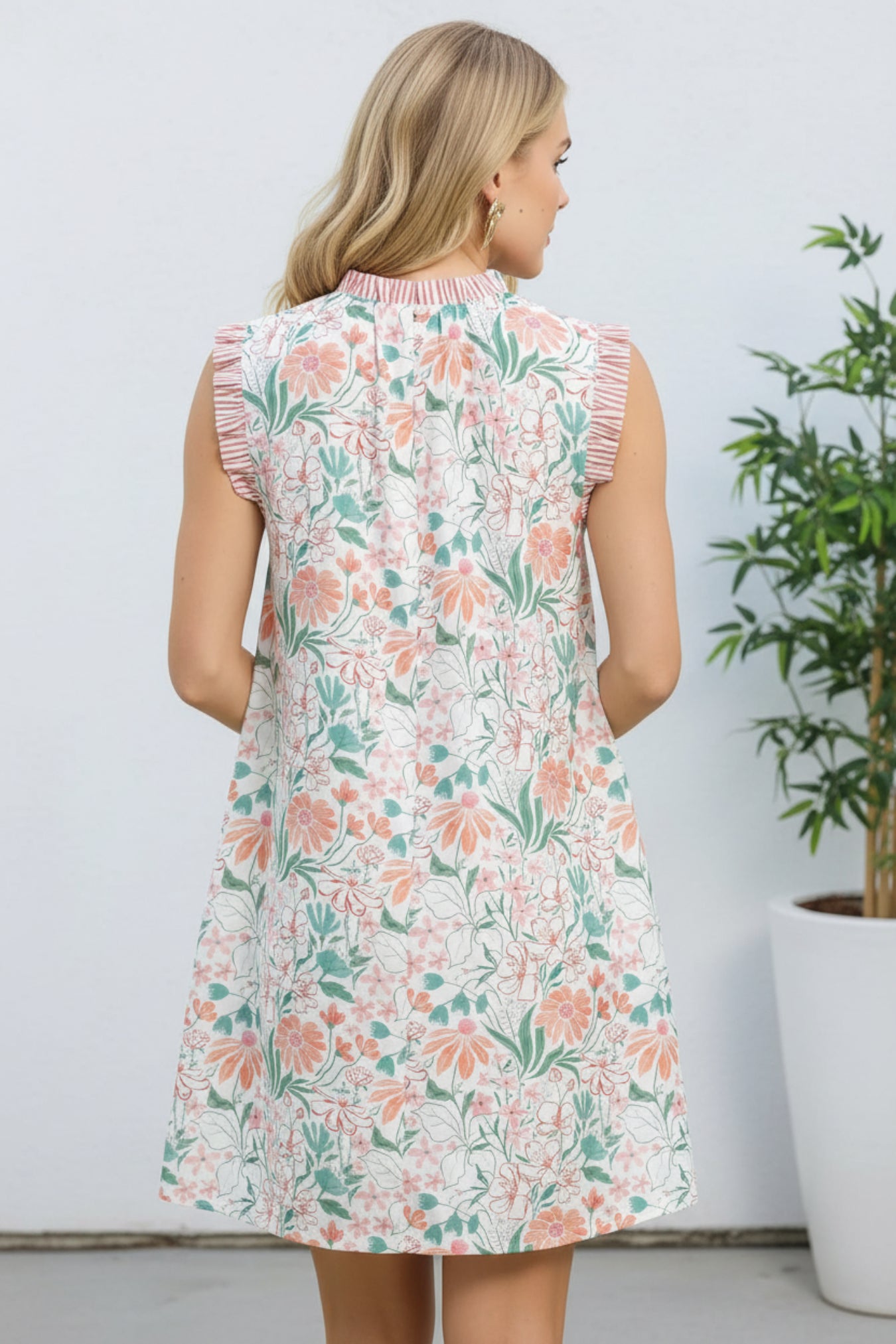 Woman wearing a floral dress with ruffled sleeves on a white background