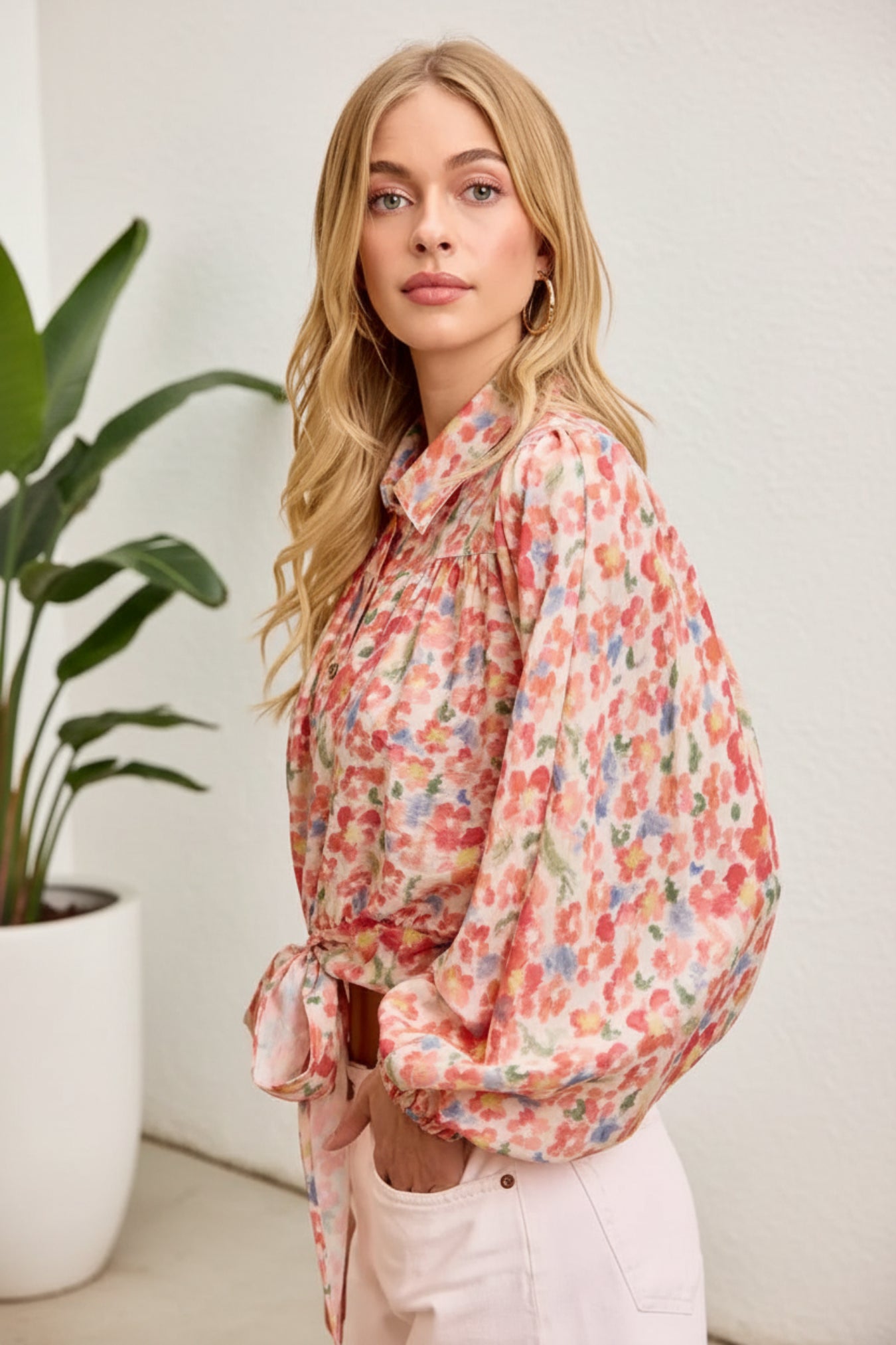 Woman wearing a floral blouse against a pink background