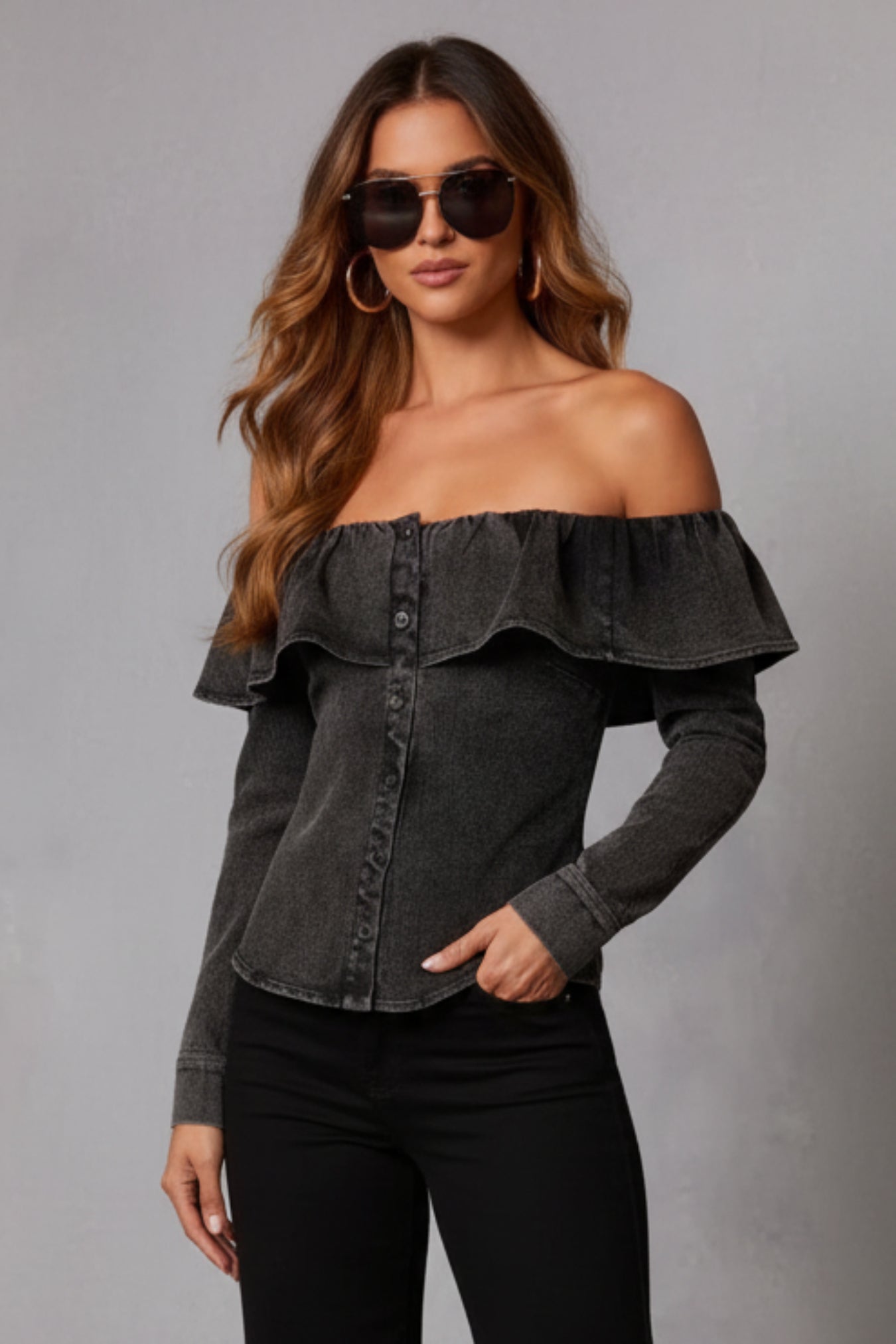 Woman wearing a gray off-shoulder top against a gray background