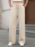 Person wearing beige wide-leg pants with a neutral background