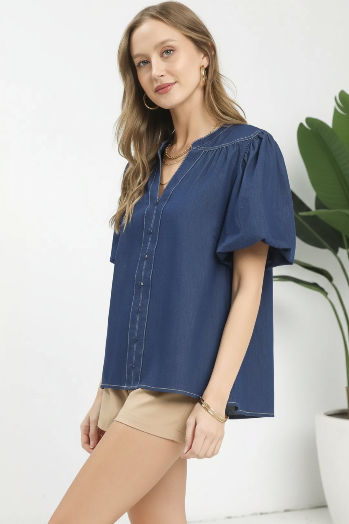 Woman wearing a blue denim blouse on a white background