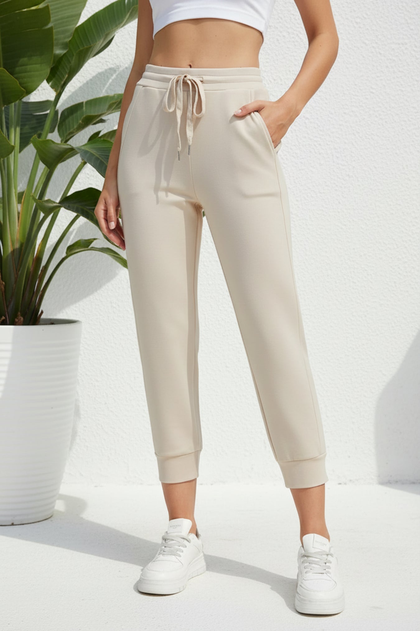 Beige jogger pants worn by a person on a beige background