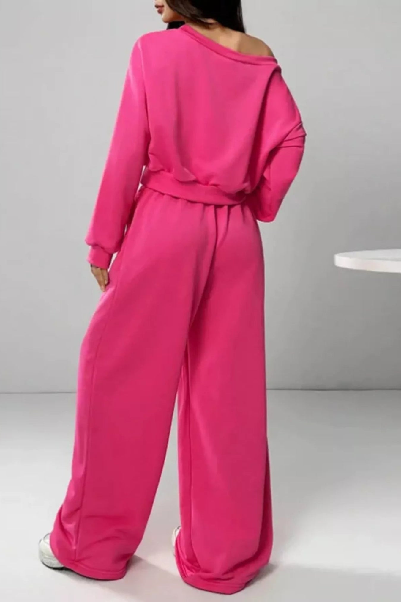 Person wearing a bright pink jumpsuit on a plain background