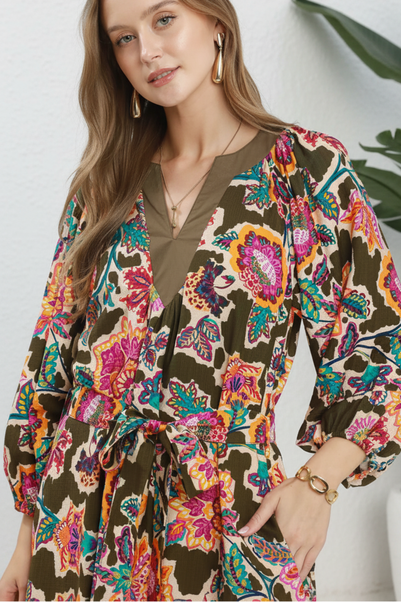 Woman wearing a colorful patterned dress with a white background