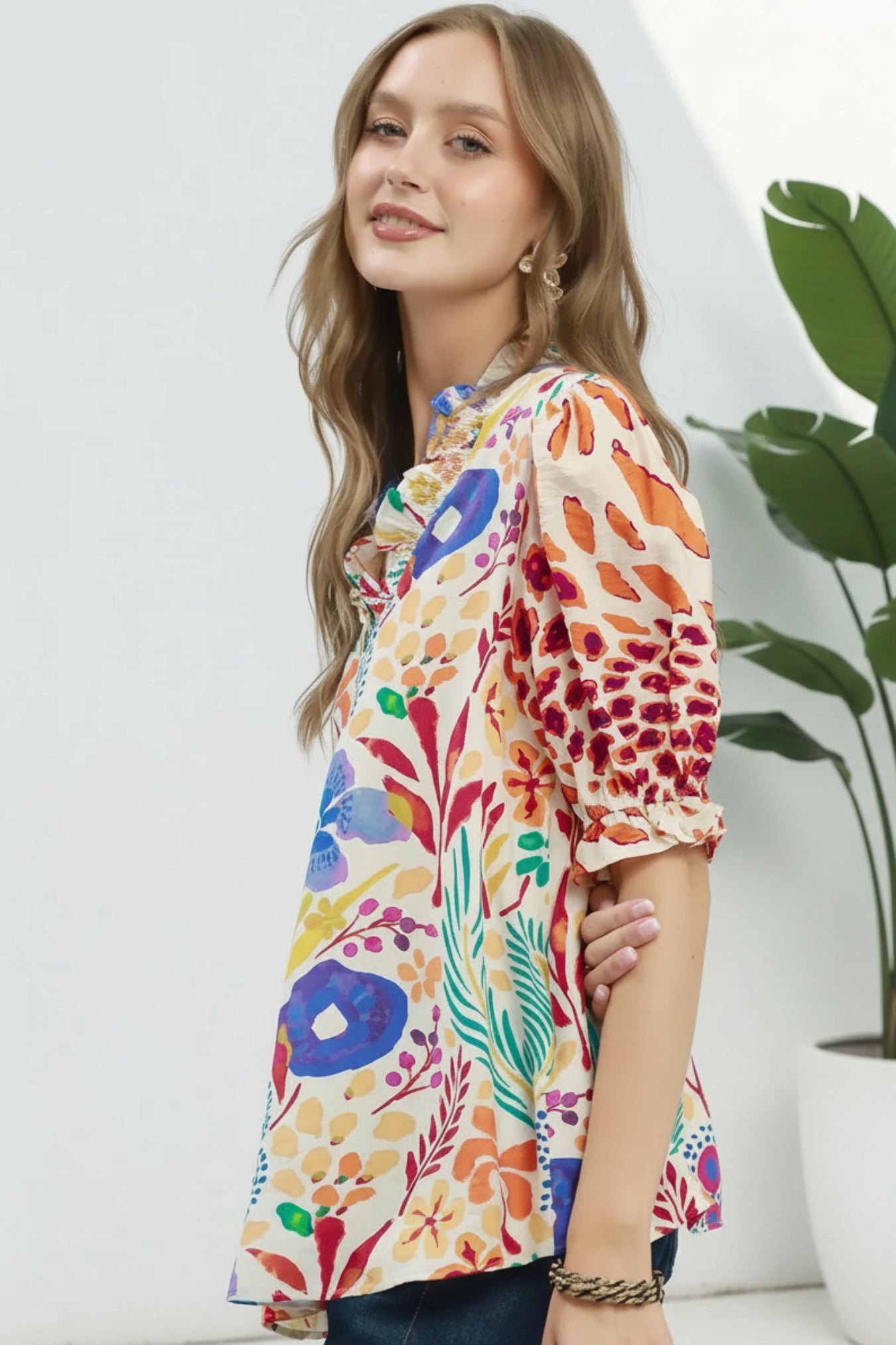 Woman wearing a colorful floral blouse on a white background