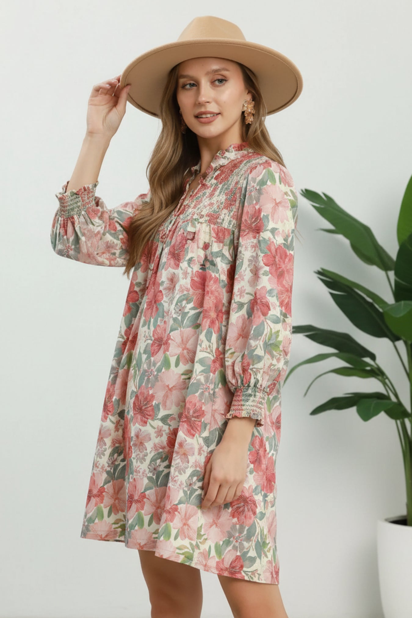 Woman wearing a floral dress with a rust mix pattern on a white background
