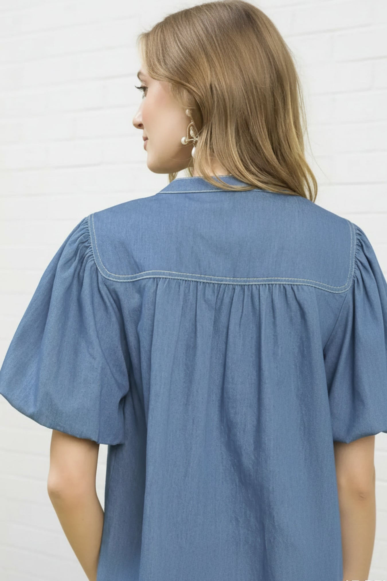 Light denim shirt worn by a person on a white background