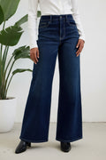 Person wearing blue wide-leg jeans on a plain background