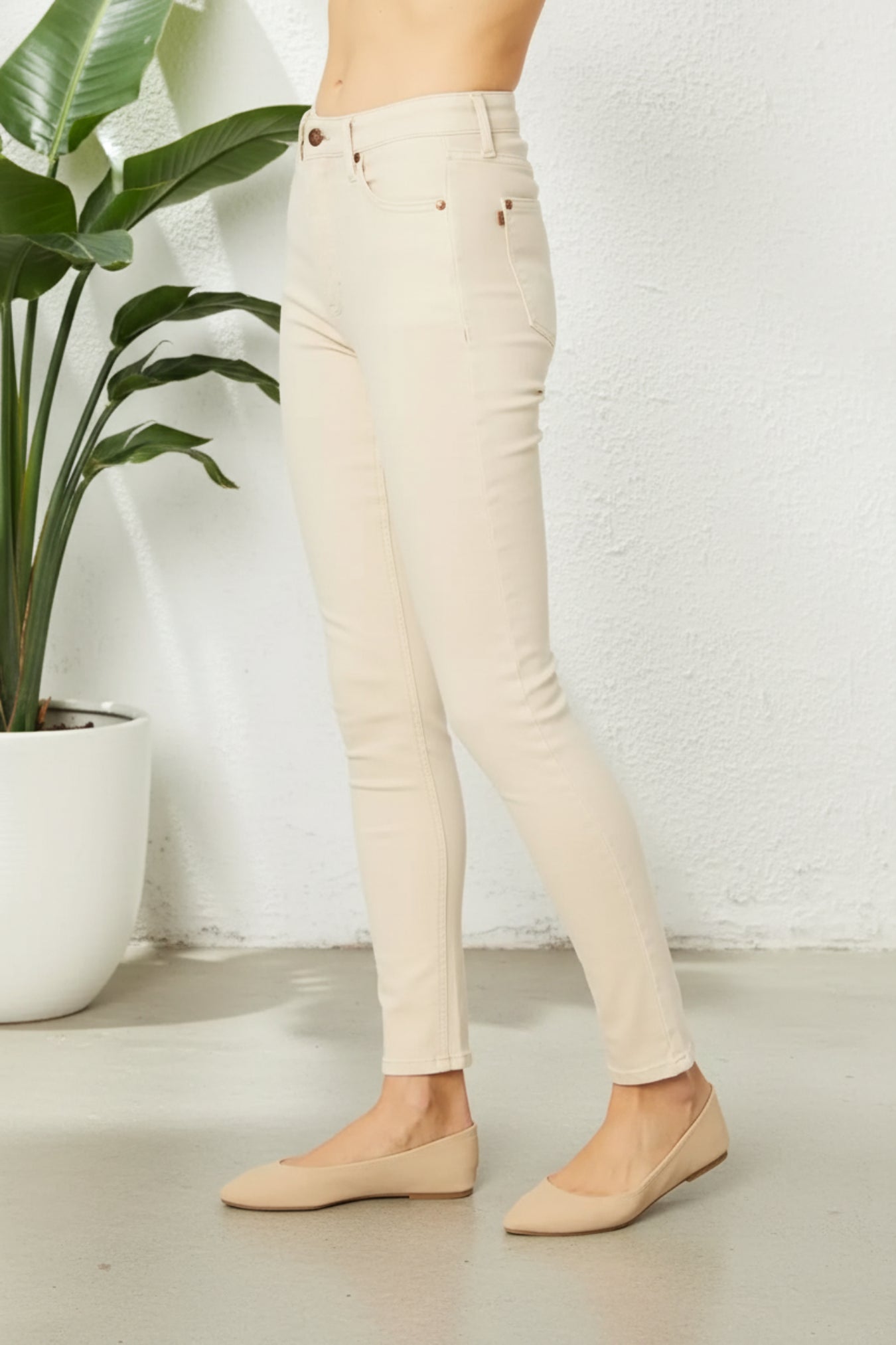 Beige pants worn by a person on a white background